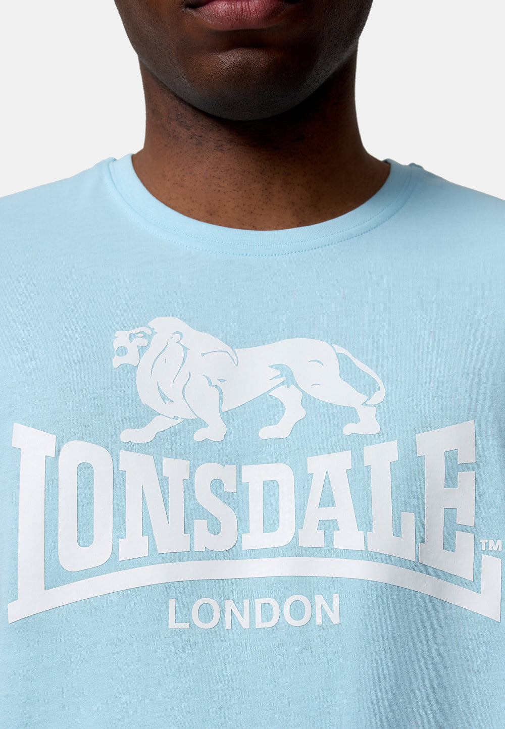 Nahaufnahme des Lonsdale Löwen-Logos als hochwertiger Druck auf dem blauen Jersey-Stoff aus 100% Baumwolle.