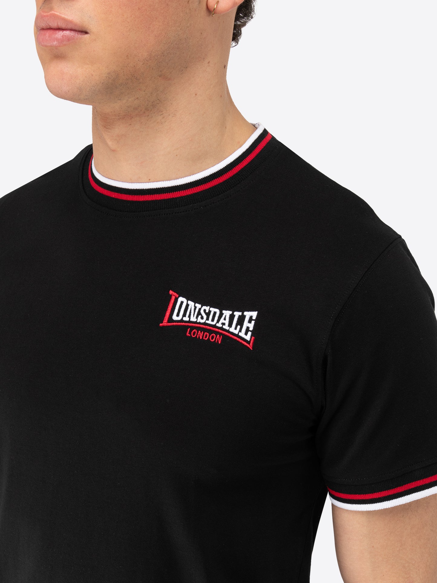 Lonsdale T-Shirt mit Logo-Stickerei auf der Brust, geripptem Rundhalsausschnitt und gestreiften Bündchen an Kragen und Ärmelabschlüssen.