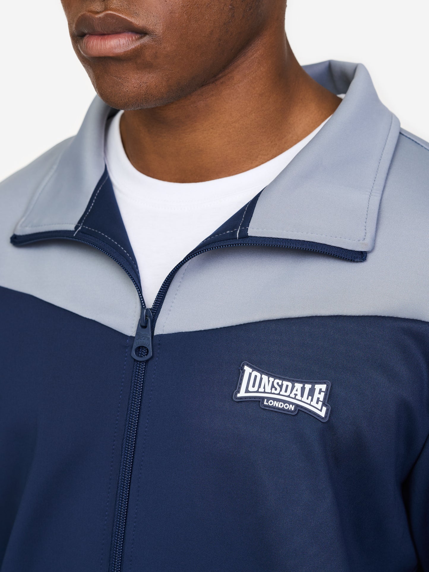 Herren Jogginganzug in schmaler Passform in Dark Navy mit Allover-Print, Stehkragen und Reißverschlusstaschen.