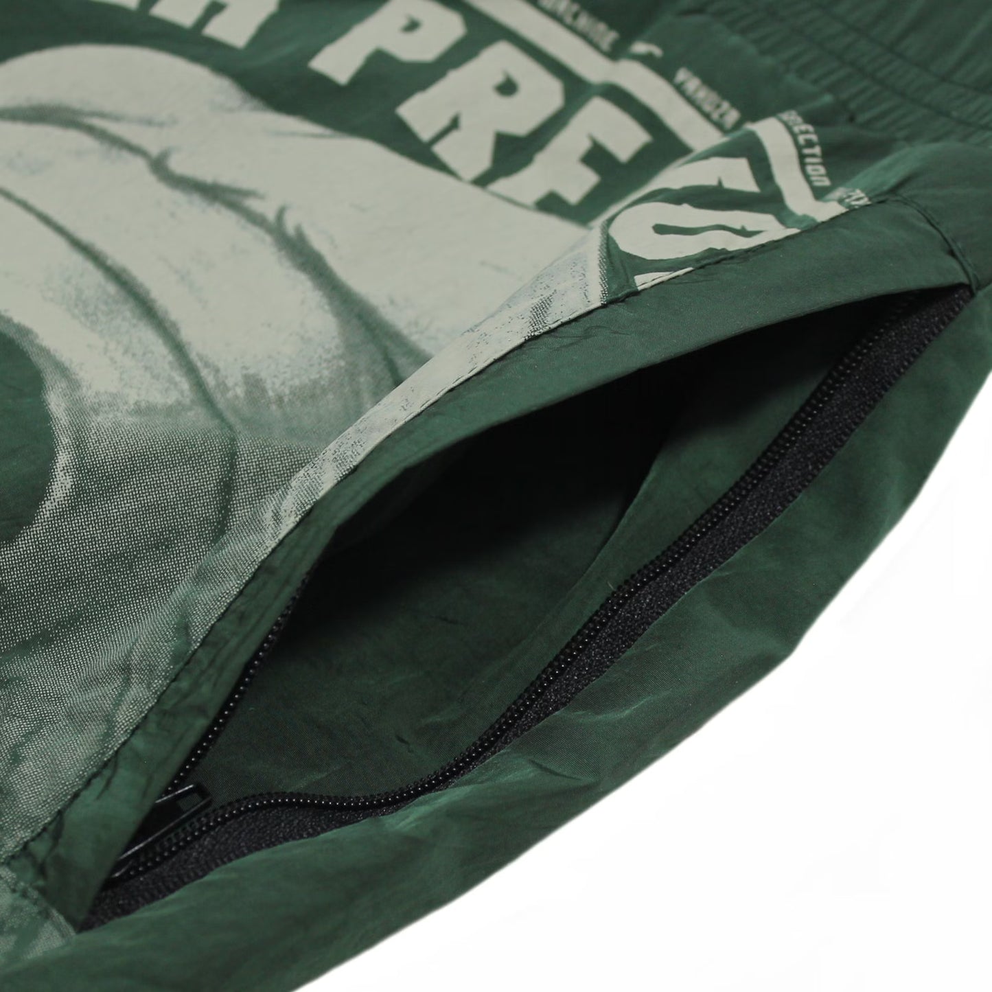 Seitliche, verschließbare Reissverschlusstasche der dunkeloliven Yakuza Premium Badeshorts.