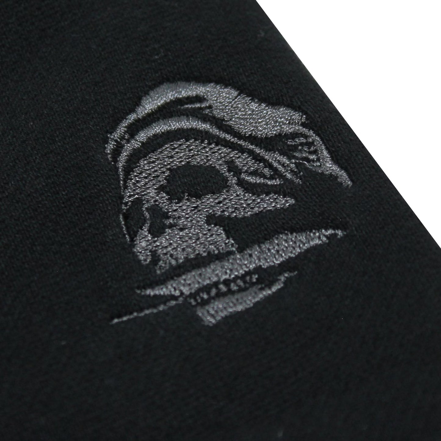 Yakuza Premium Herren Jogginghose Schwarz Detailansicht kleine Totenkopf-Stickerei in Grau auf dem Hosenbein.