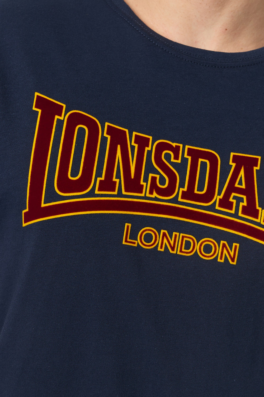 Nahaufnahme des rot-gelben Lonsdale London Logo-Frontdrucks auf dem navy blauen Classic Baumwoll-T-Shirt.
