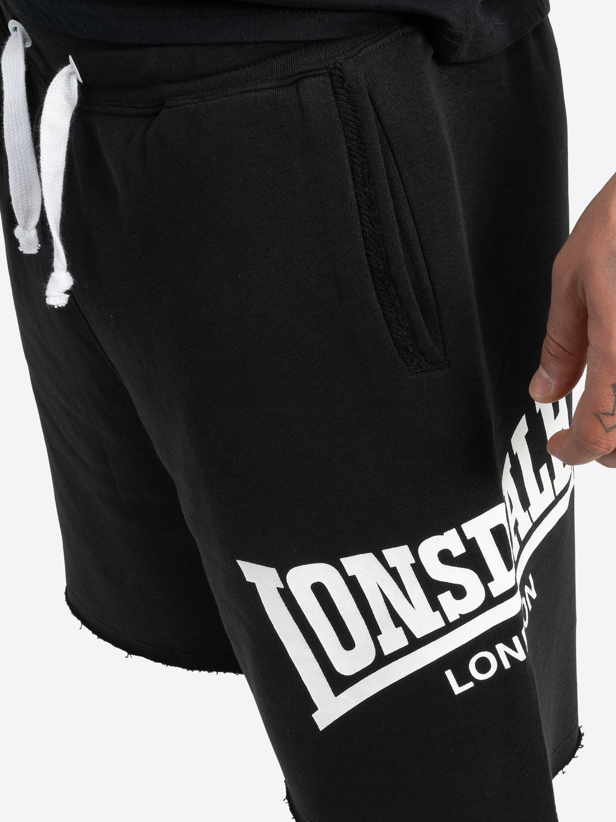 Detailansicht schwarze Lonsdale Sportshorts mit weissem Logo.