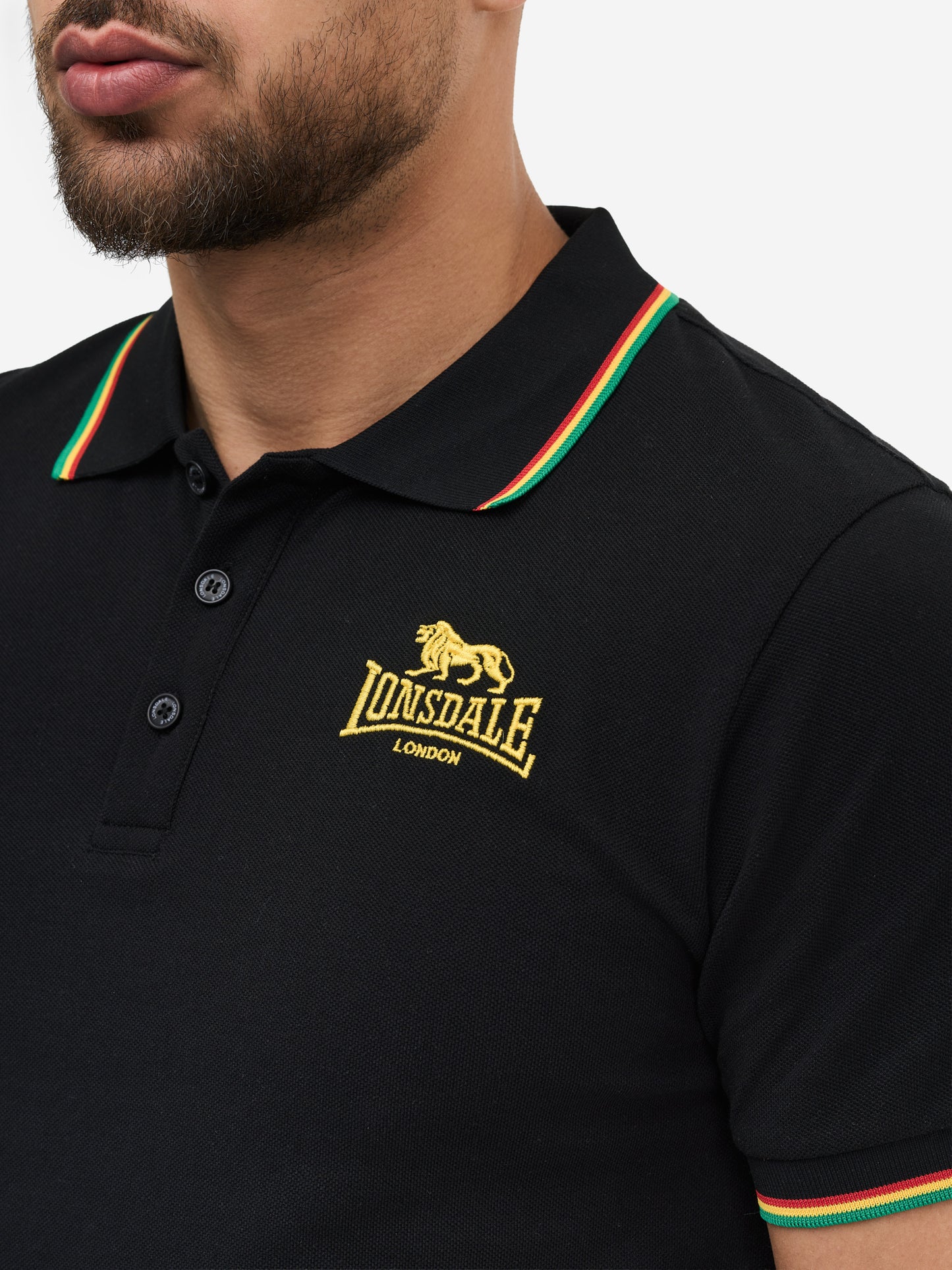 Nahaufnahme: Lonsdale Löwen-Stickerei und rot-weiße Kontraststreifen an Kragen und Ärmelsaum