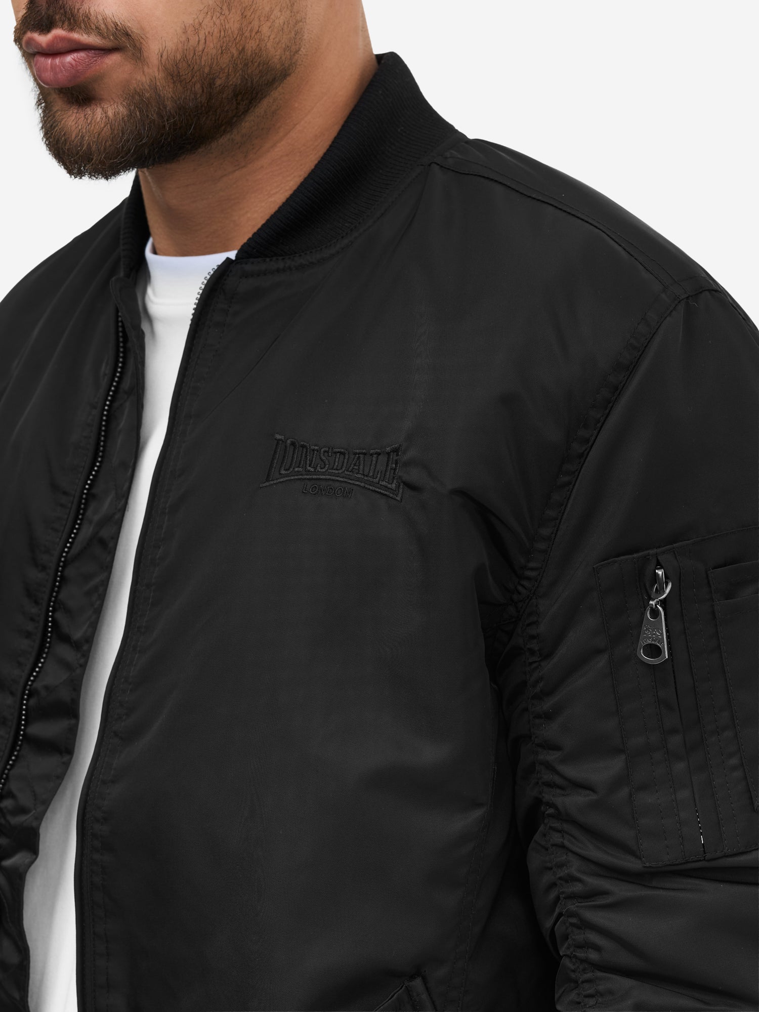 Nahaufnahme Lonsdale Jacke mit Ärmeltasche, Druckknopftaschen und kontrastfarbenem Innenfutter.