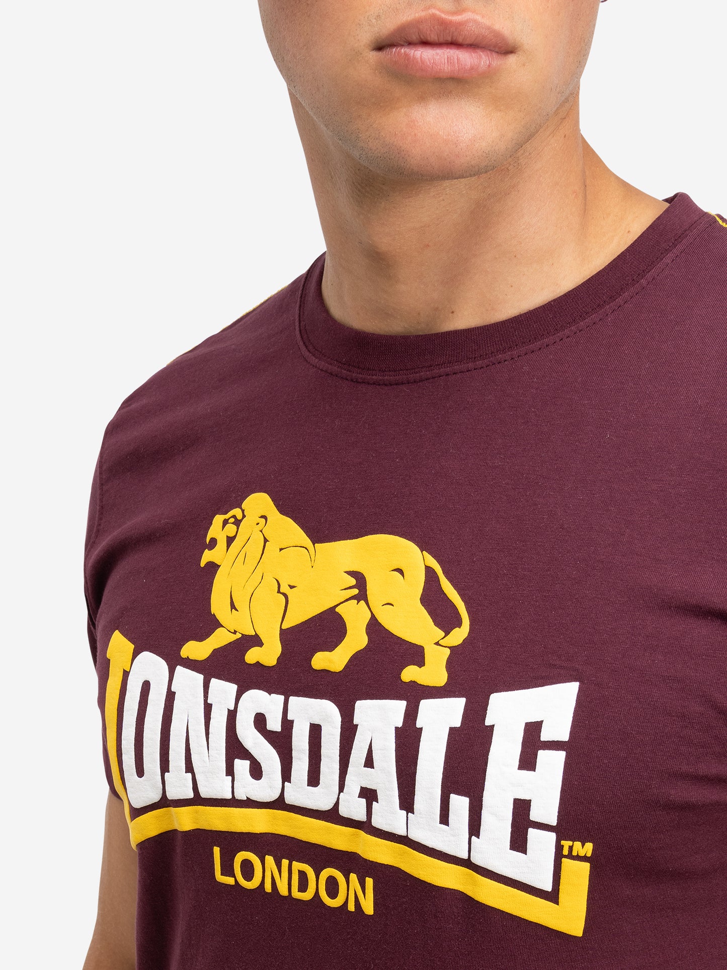 Nahaufnahme des zweifarbigen Lonsdale Logos und Union Jack Labels an der Seitennaht, Oxblood Baumwolle.