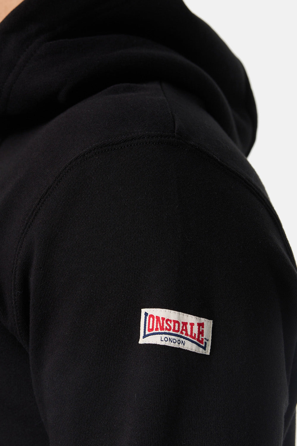 Nahaufnahme: Lonsdale Flockdruck auf weichem Fleece-Stoff aus 80% gekämmter Baumwolle und 20% Polyester.