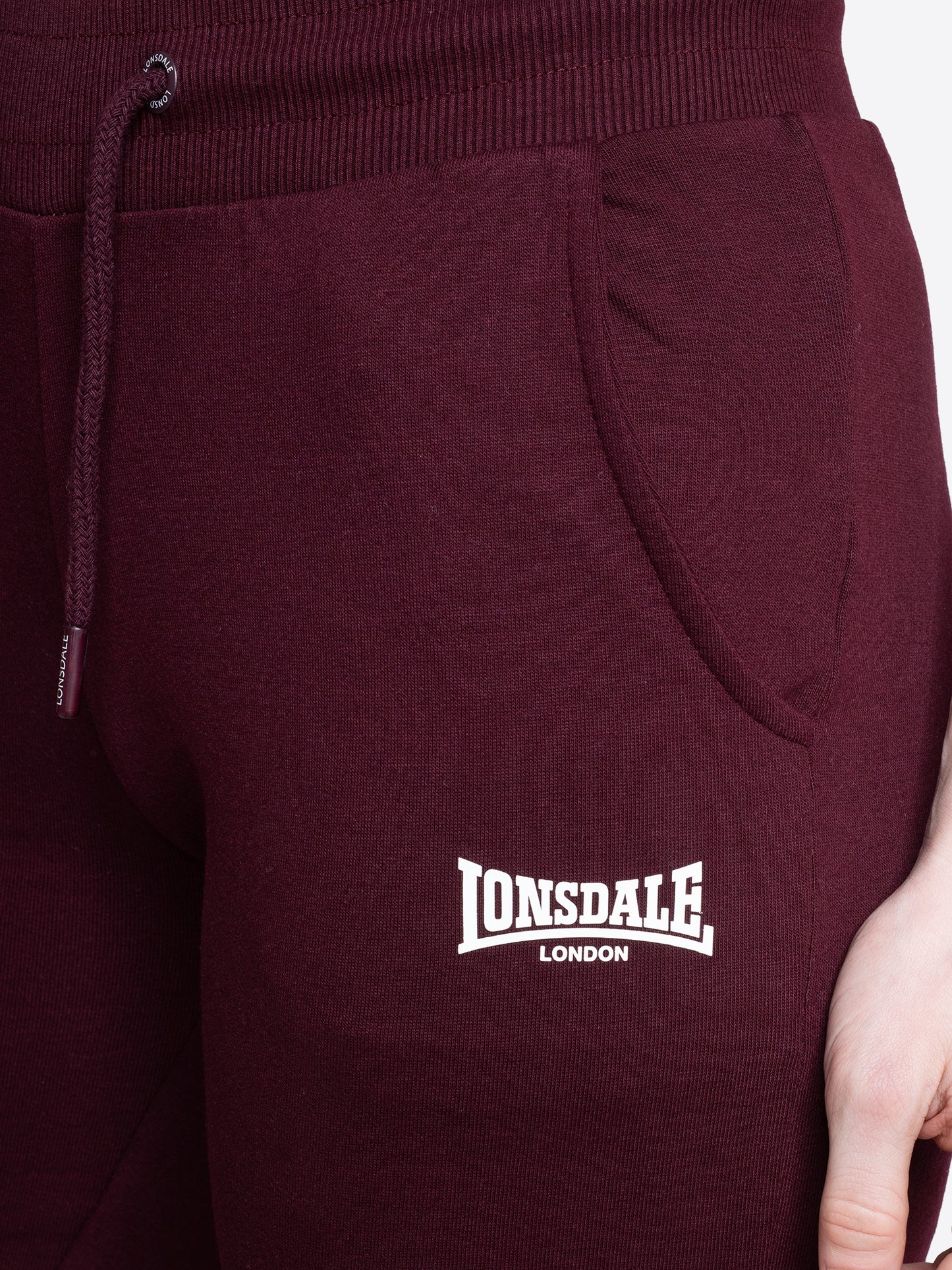 Nahaufnahme vom Lonsdale London Logo-Druck auf der Jogginghose in Oxblood
