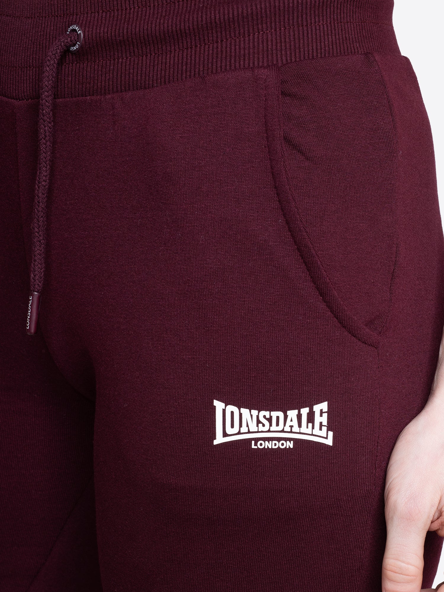 Nahaufnahme vom Lonsdale London Logo-Druck auf der Jogginghose in Oxblood
