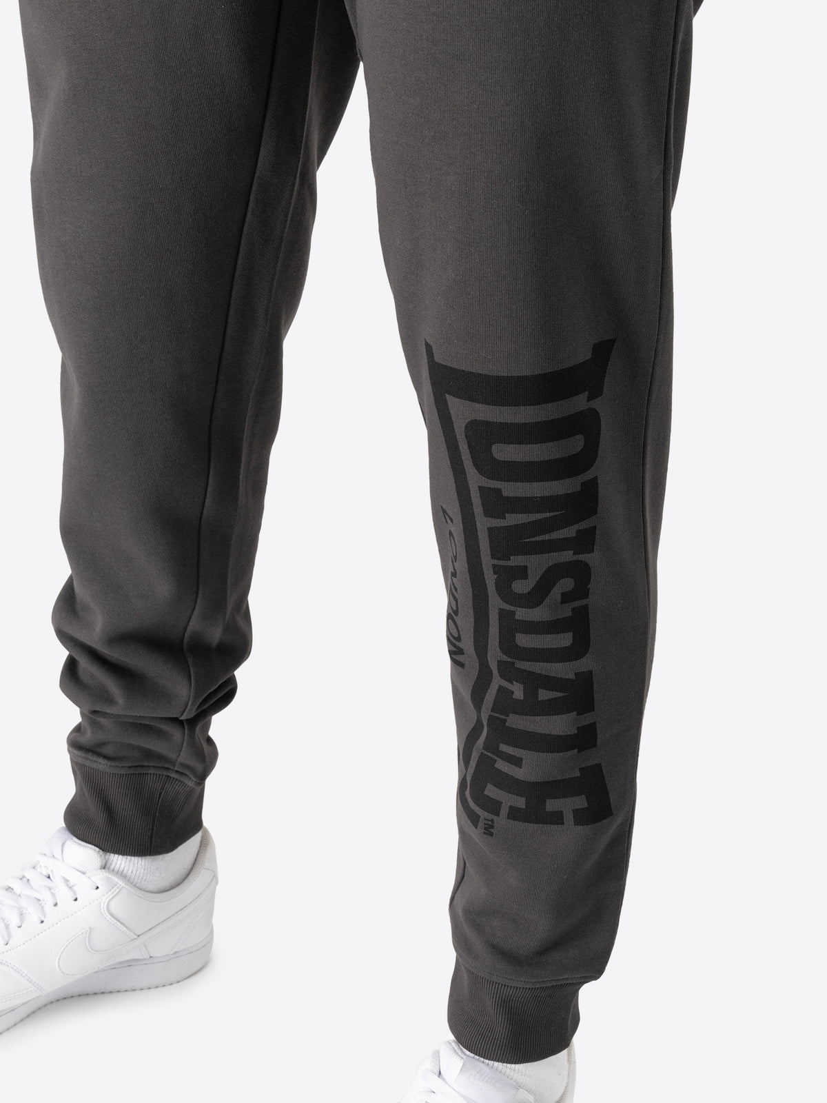 Nahaufnahme des Lonsdale London Schriftzugs auf dem Bein der grauen Jogginghose.