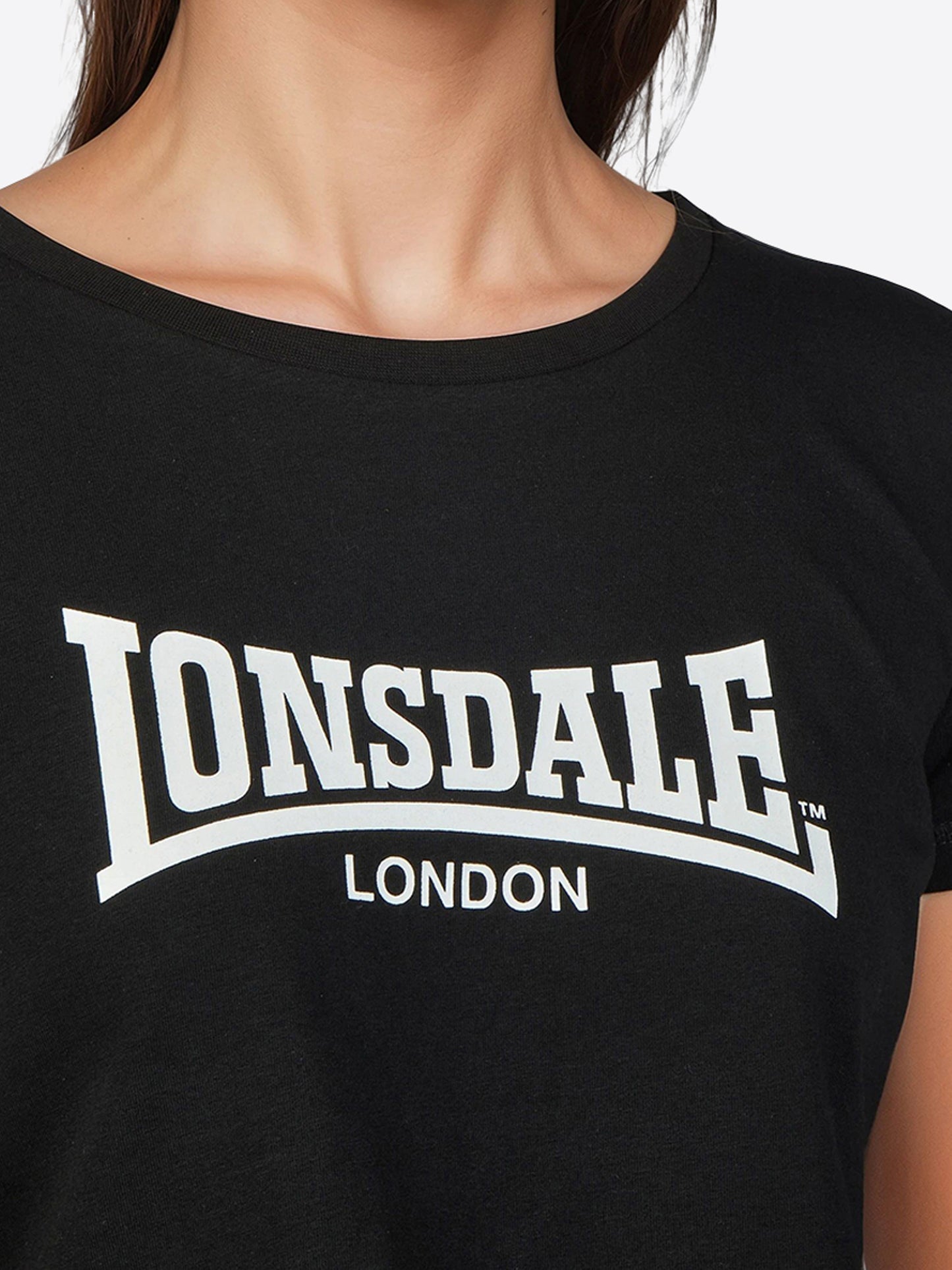 Lonsdale Frauen Set mit kurz geschnittenem T-Shirt und 7/8-Leggings, beide mit kontrastfarbenem Logo-Druck auf Brust und linkem Bein.