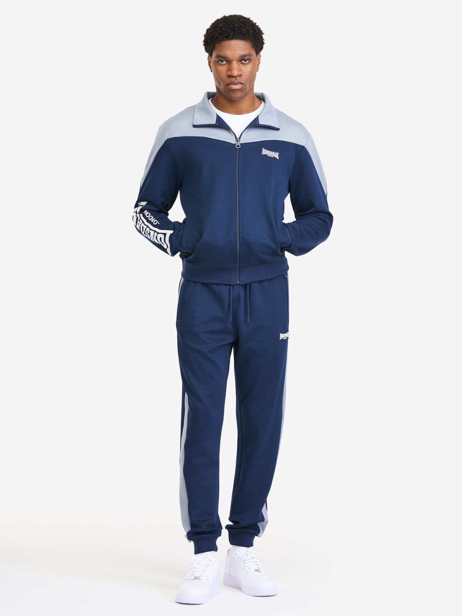 Herren Jogginganzug in schmaler Passform in Dark Navy mit Allover-Print, Stehkragen und Reißverschlusstaschen.