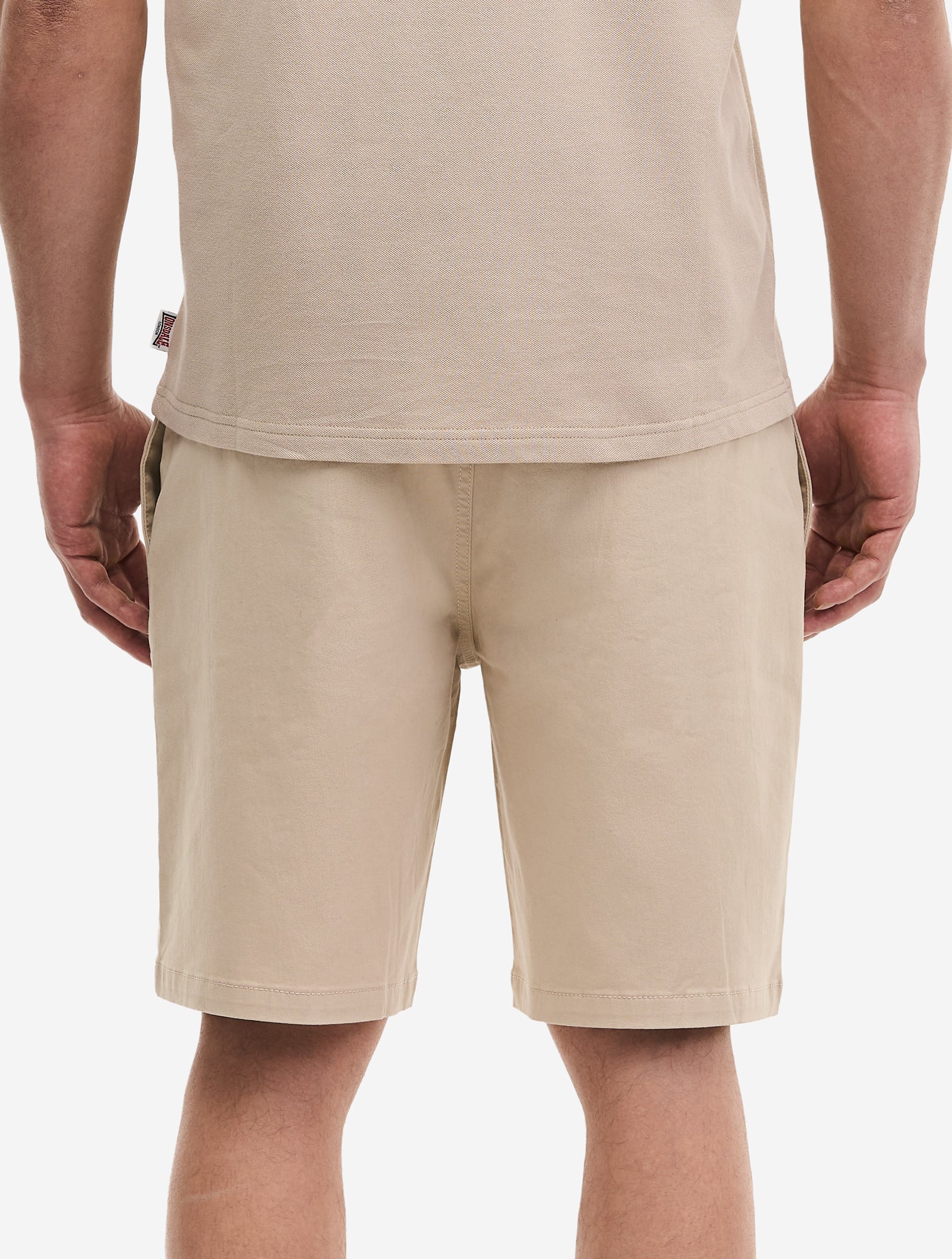 Rückseite der beigen Lonsdale Helsden Shorts mit Paspeltaschen und Kunstleder-Abzeichen am Bund.