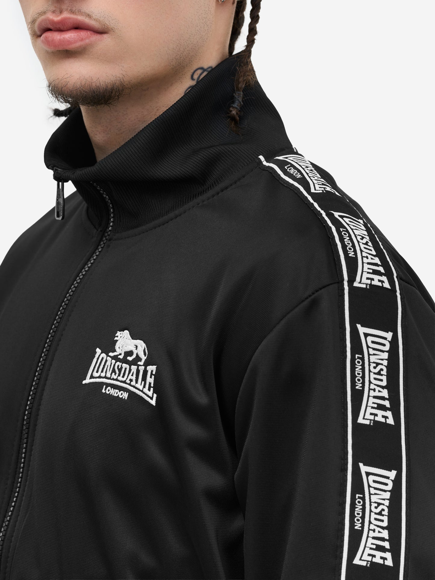 Nahaufnahme der gewebten Lonsdale Logo-Tapes entlang der Ärmel und elastischer Rippbündchen.