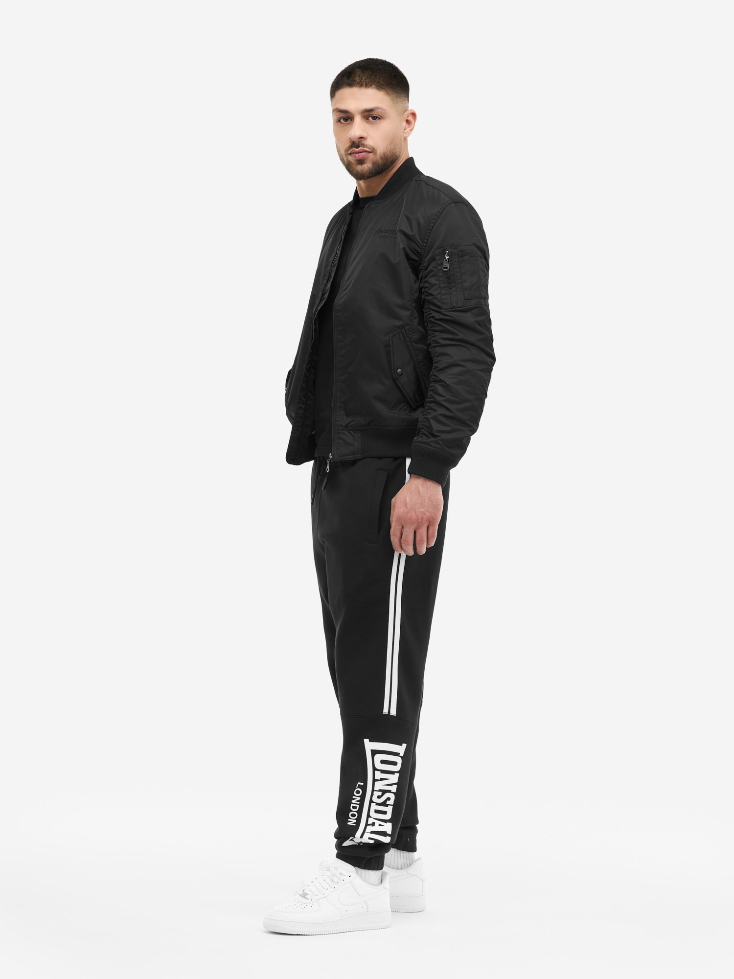 Schwarze Lonsdale Jogginghose für Herren in Regular Fit. Fleece-Stoff mit seitlichen Streifen und markantem Logo-Detail.