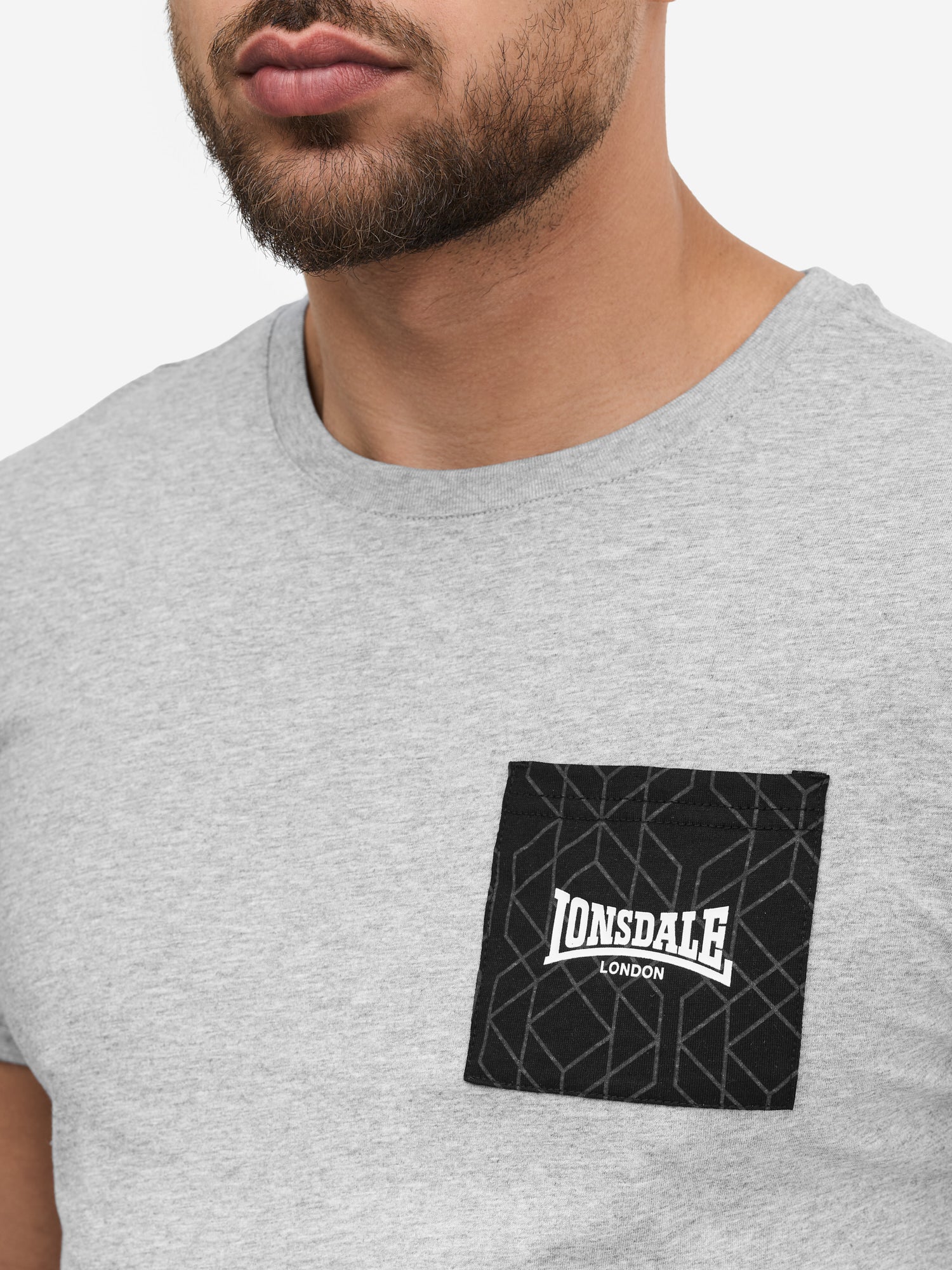  Nahaufnahme der Lonsdale Logo-Brusttasche, 100% gekämmte Baumwolle.