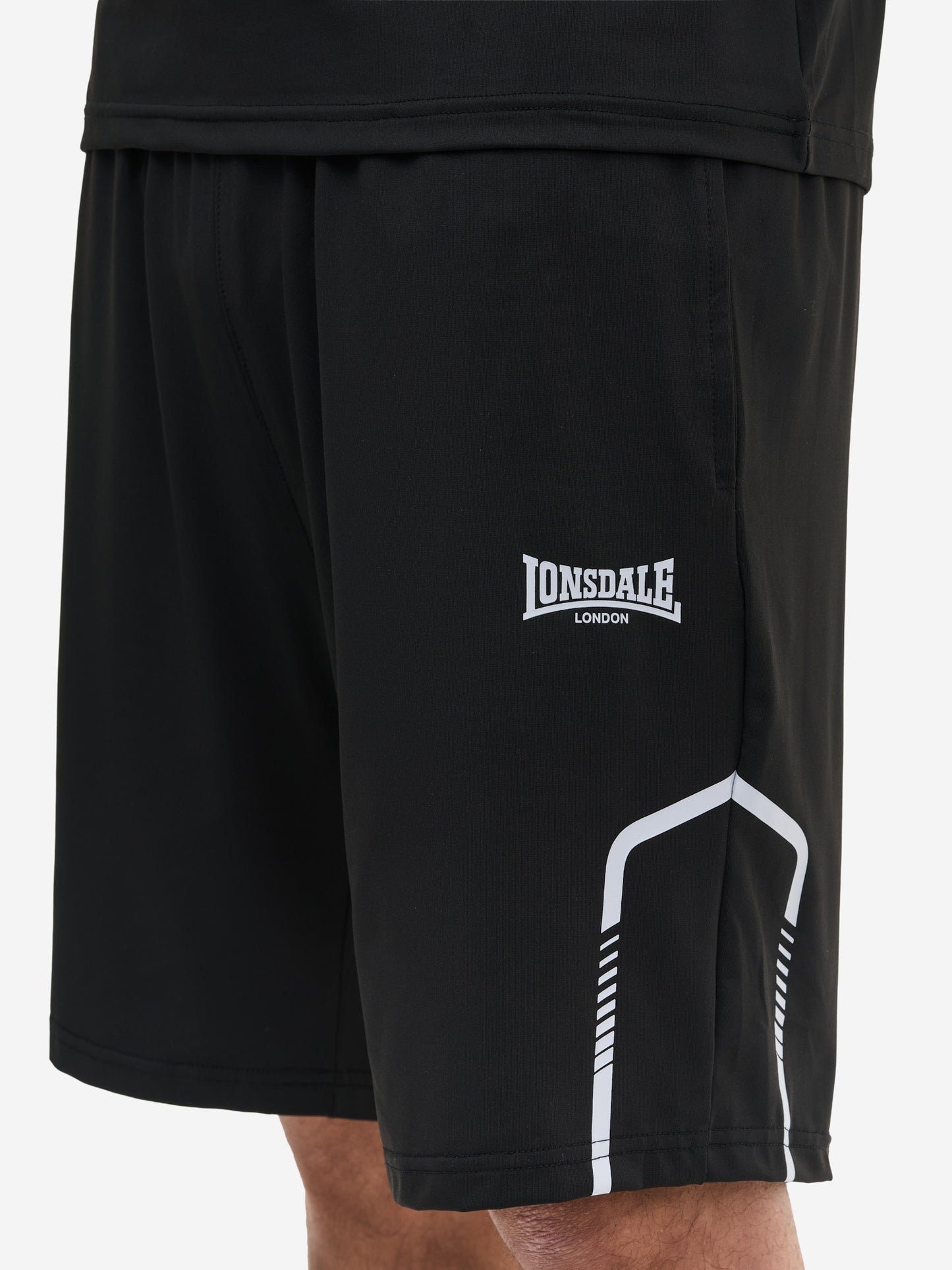 Nahaufnahme Lonsdale Logo und Materialstruktur des schwarzen Funktionsshorts aus 100% Polyester.