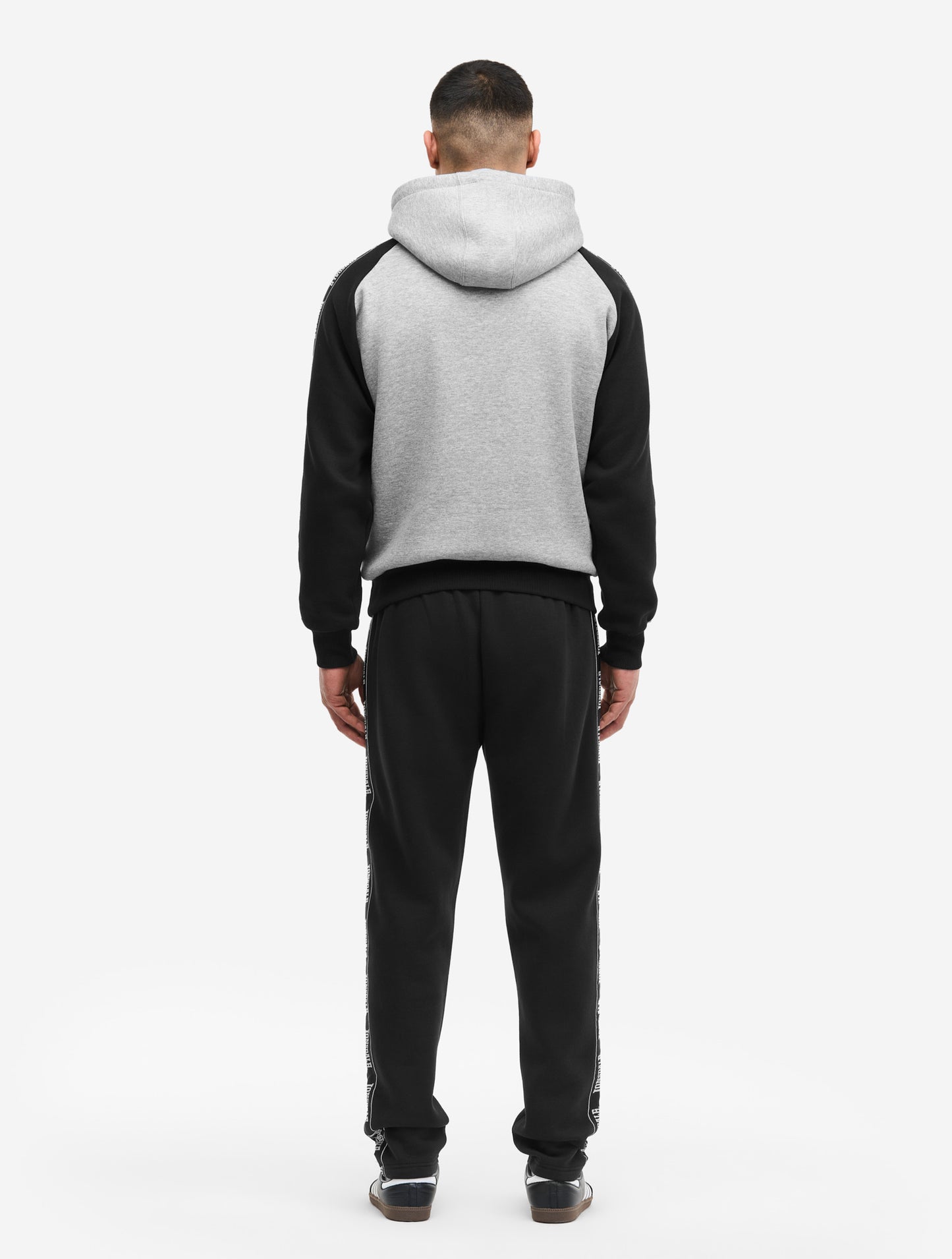 Rückansicht Lonsdale Jogginganzug in Schwarz-Grau, Sweatjacke mit Raglanärmeln und Hose mit seitlichen Logo-Bändern.