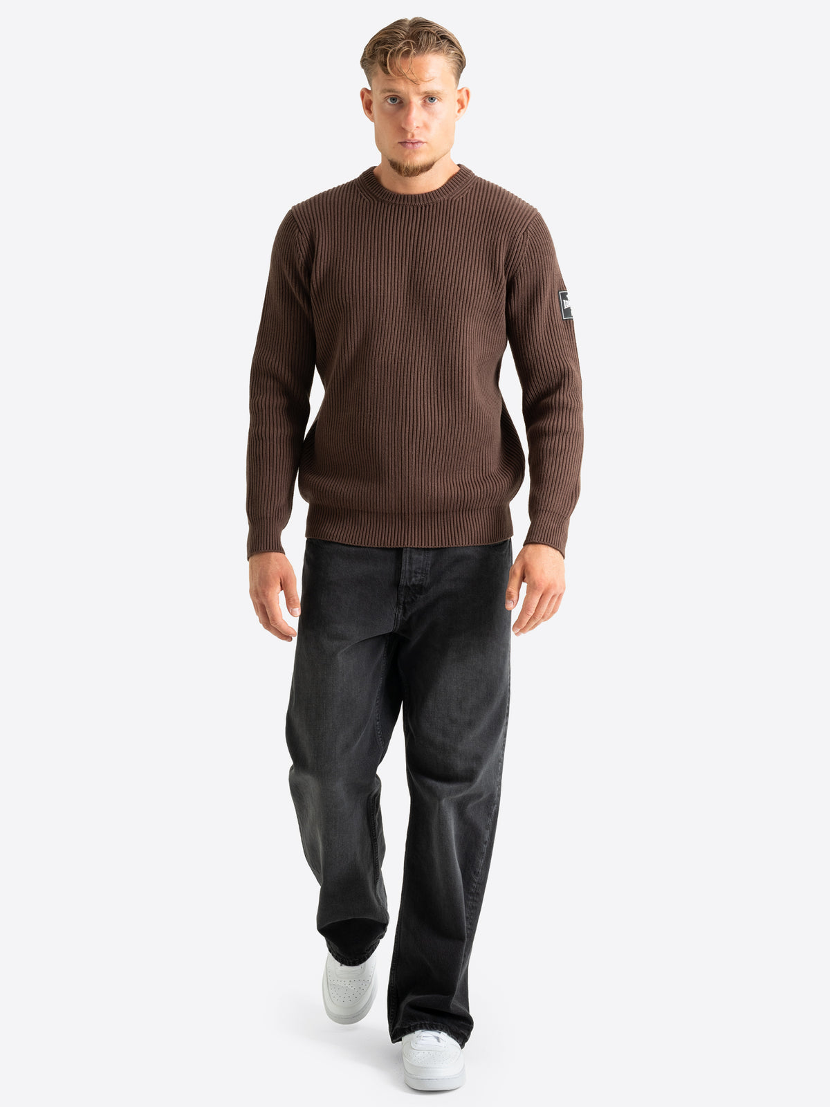 Brauner Herren-Strickpullover in Regular Fit mit Rundhalsausschnitt und 3D-Gummidruck-Patch am linken Ärmel.
