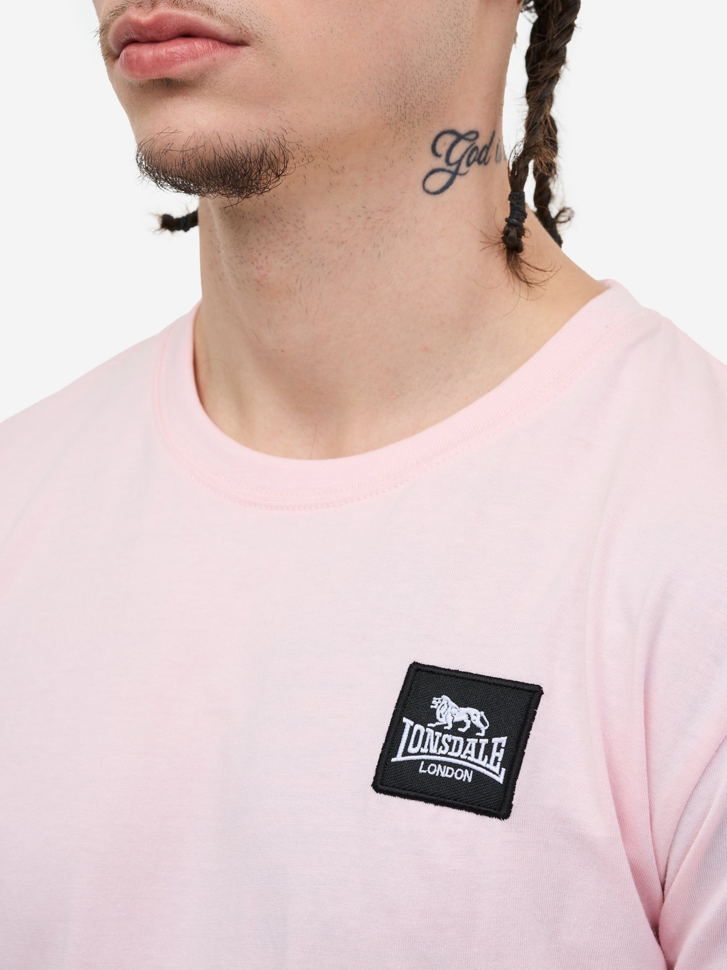 Nahaufnahme des Lonsdale-Patches auf schwarzer, gekämmter Baumwolle; zeigt das quadratische Logo-Label und die feine Jersey-Struktur.