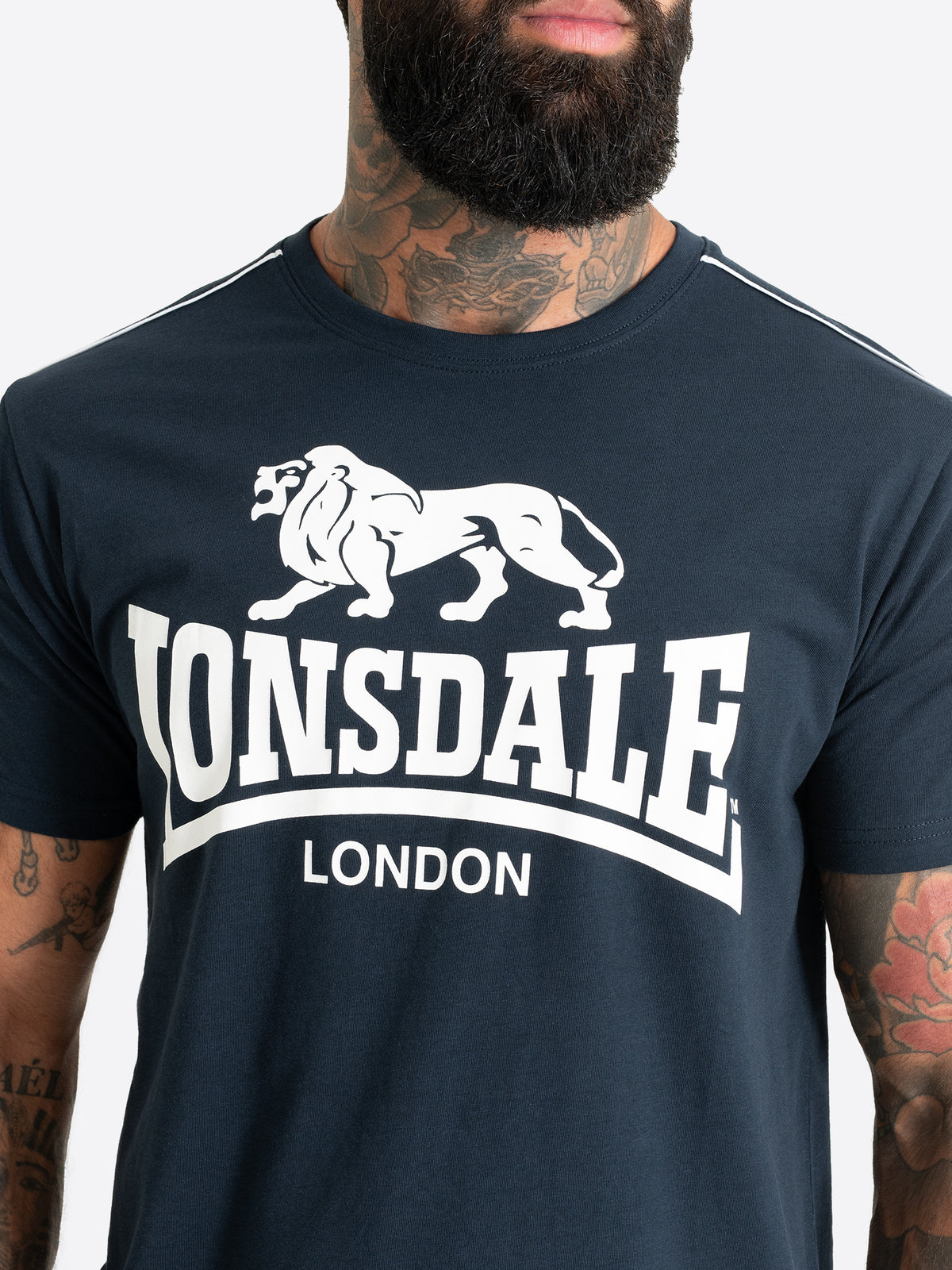 Nahaufnahme des weissen Lonsdale London Logo-Drucks auf der Brust des Herren T-Shirts in Dark Navy.