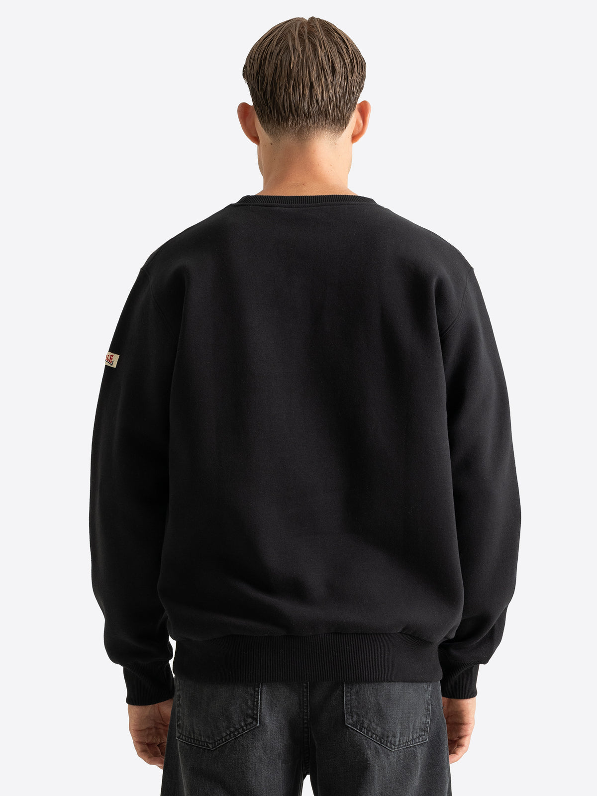 Rückansicht des schlichten schwarzen Lonsdale Herren-Sweatshirts mit elastischen Rippbündchen.
