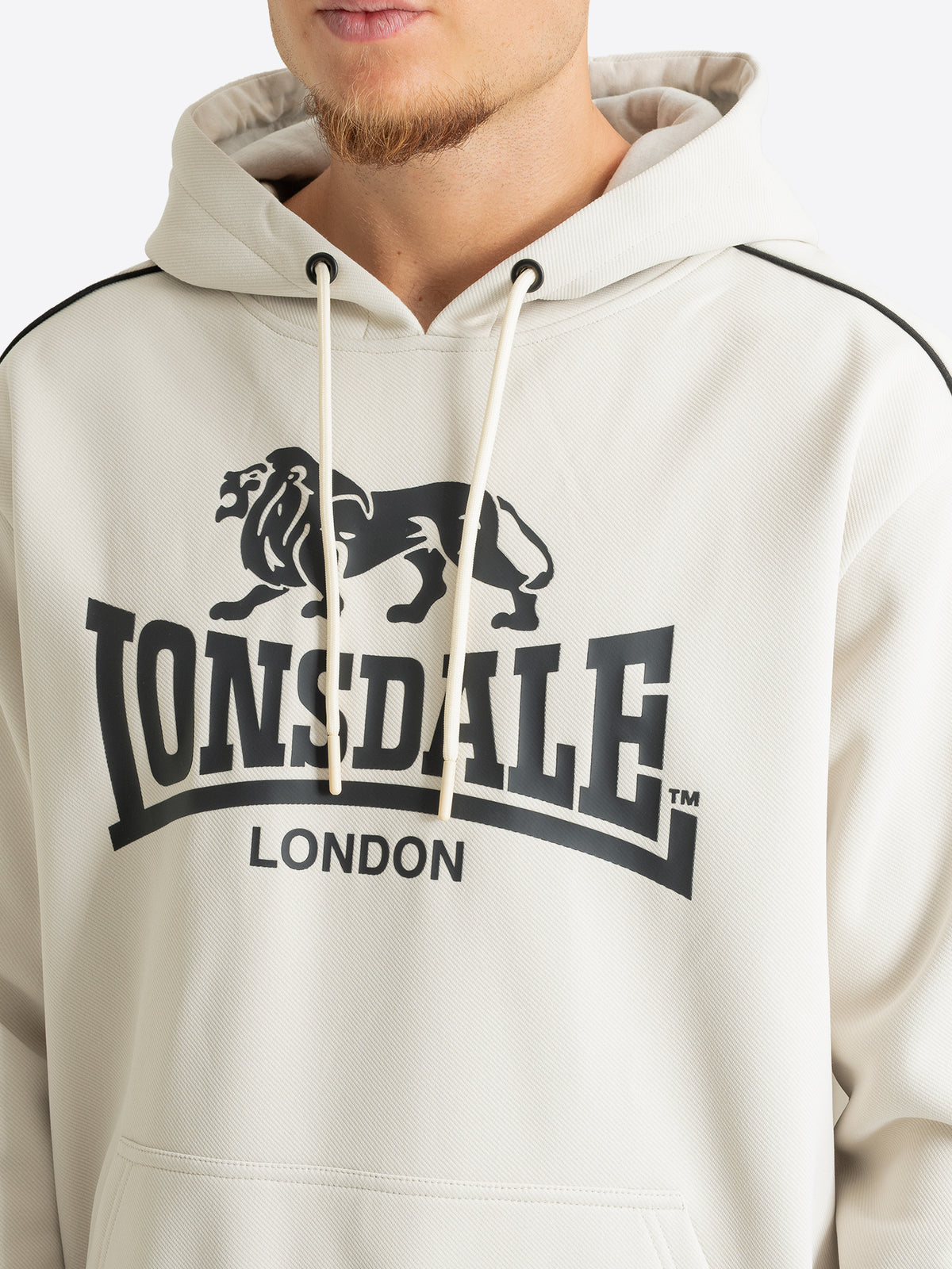 Nahaufnahme des grossen schwarzen Lonsdale Logo-Drucks auf dem Herren-Hoodie in Off-White.

