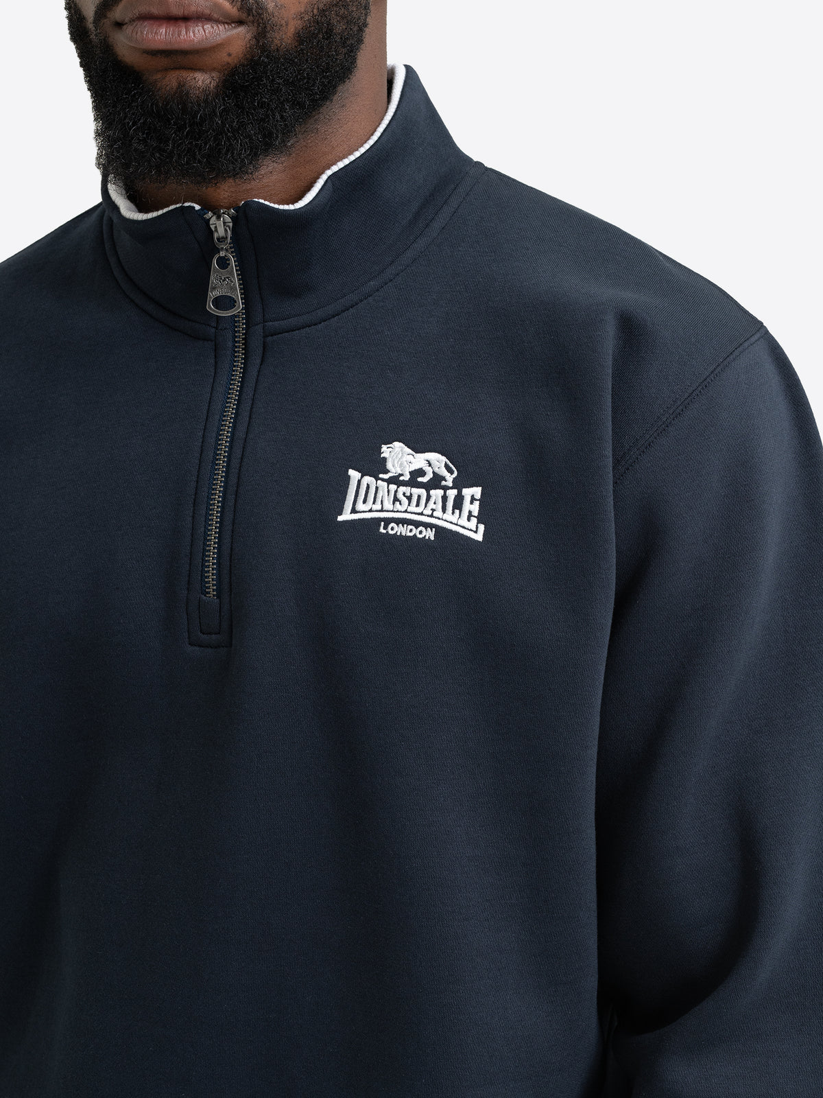 Nahaufnahme des Half-Zip Reissverschlusses und der Lonsdale Logo-Stickerei auf dem Sweatshirt in Dark Navy.
