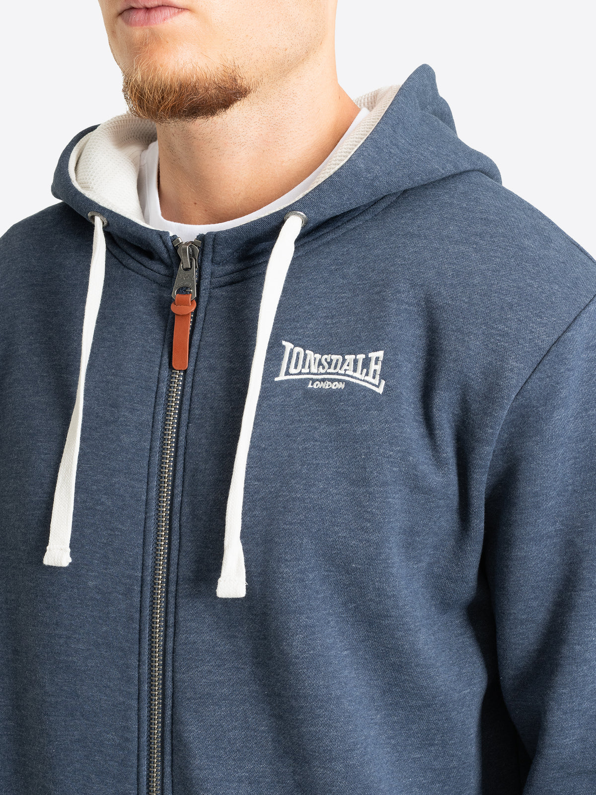 Nahaufnahme des Lonsdale-Logosticks auf der Brust der dunkelblauen Sweatjacke.