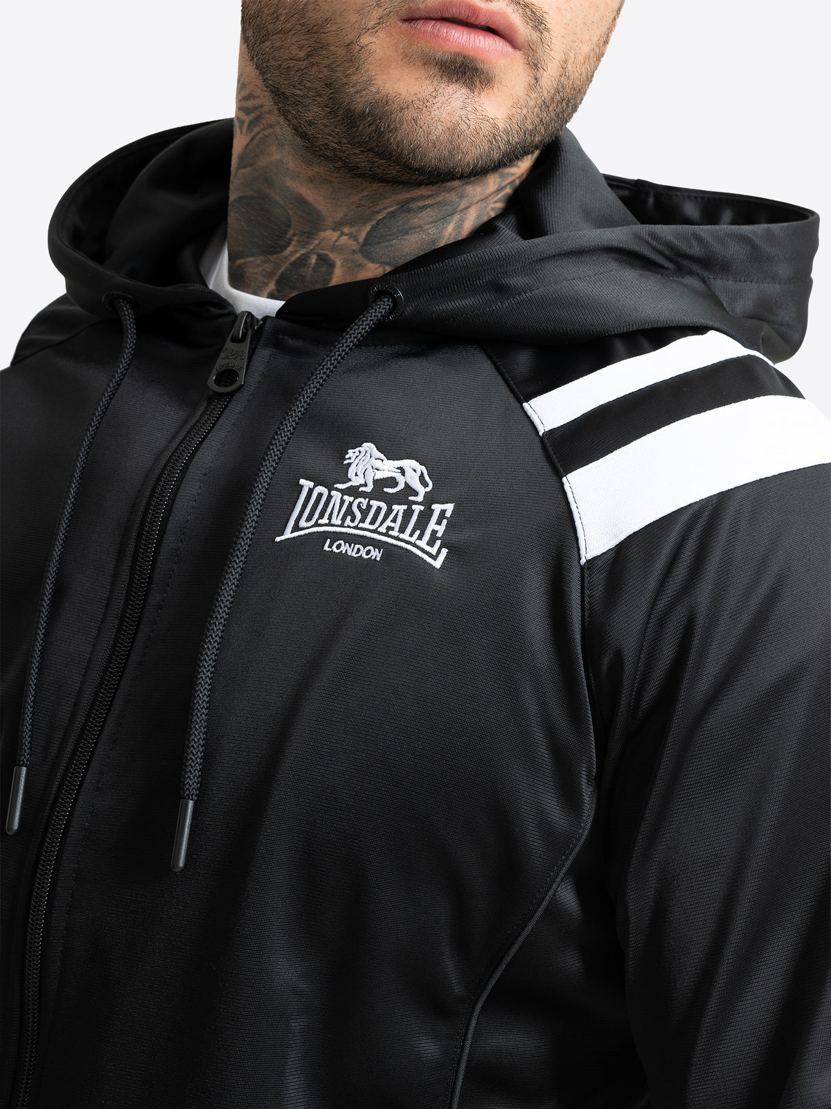 Nahaufnahme der Lonsdale Herren-Trainingsjacke mit gesticktem Logo und weissen Schulterstreifen