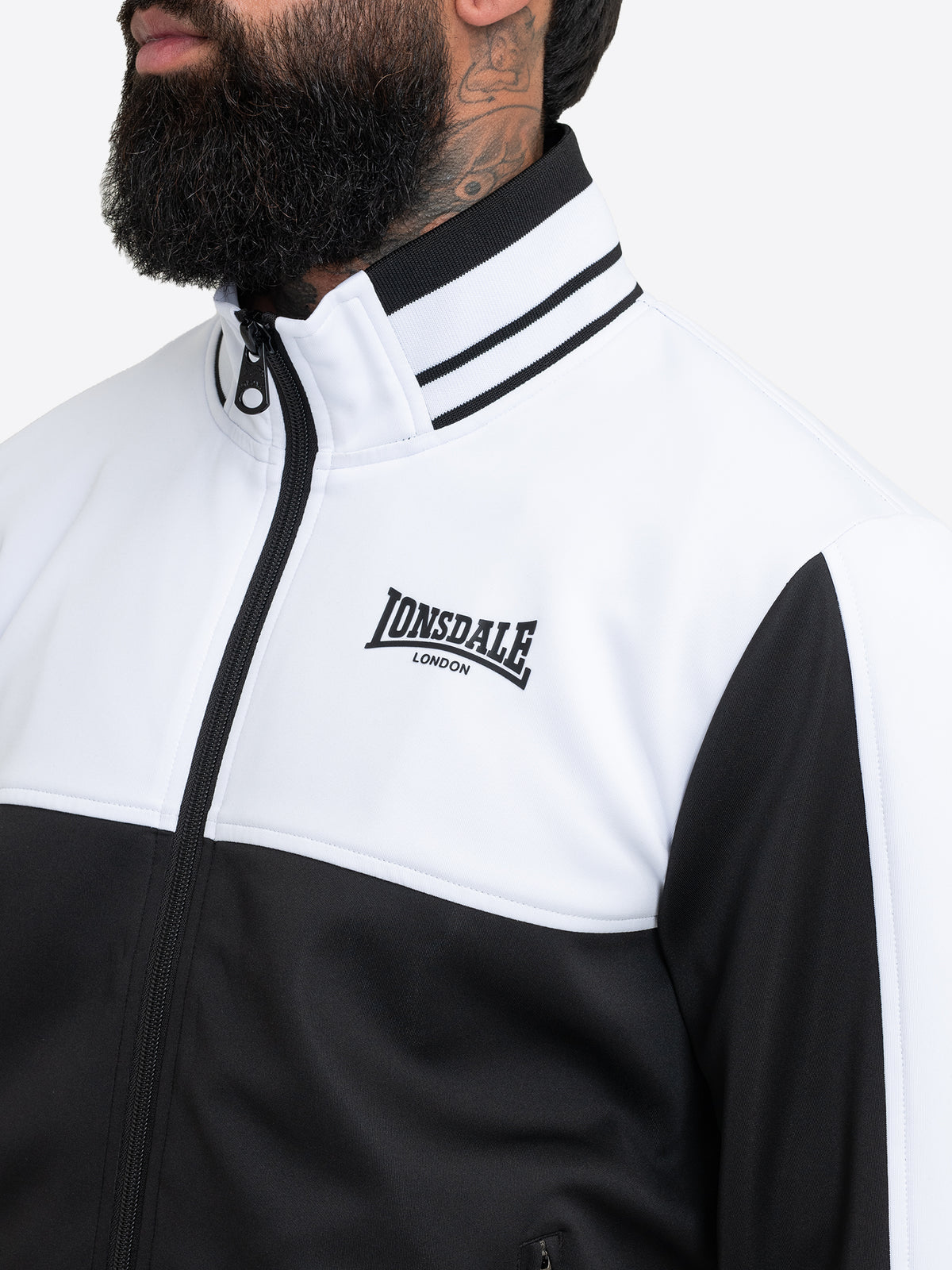 Detailansicht der Lonsdale Joggingjacke mit Stehkragen und gesticktem Logo.