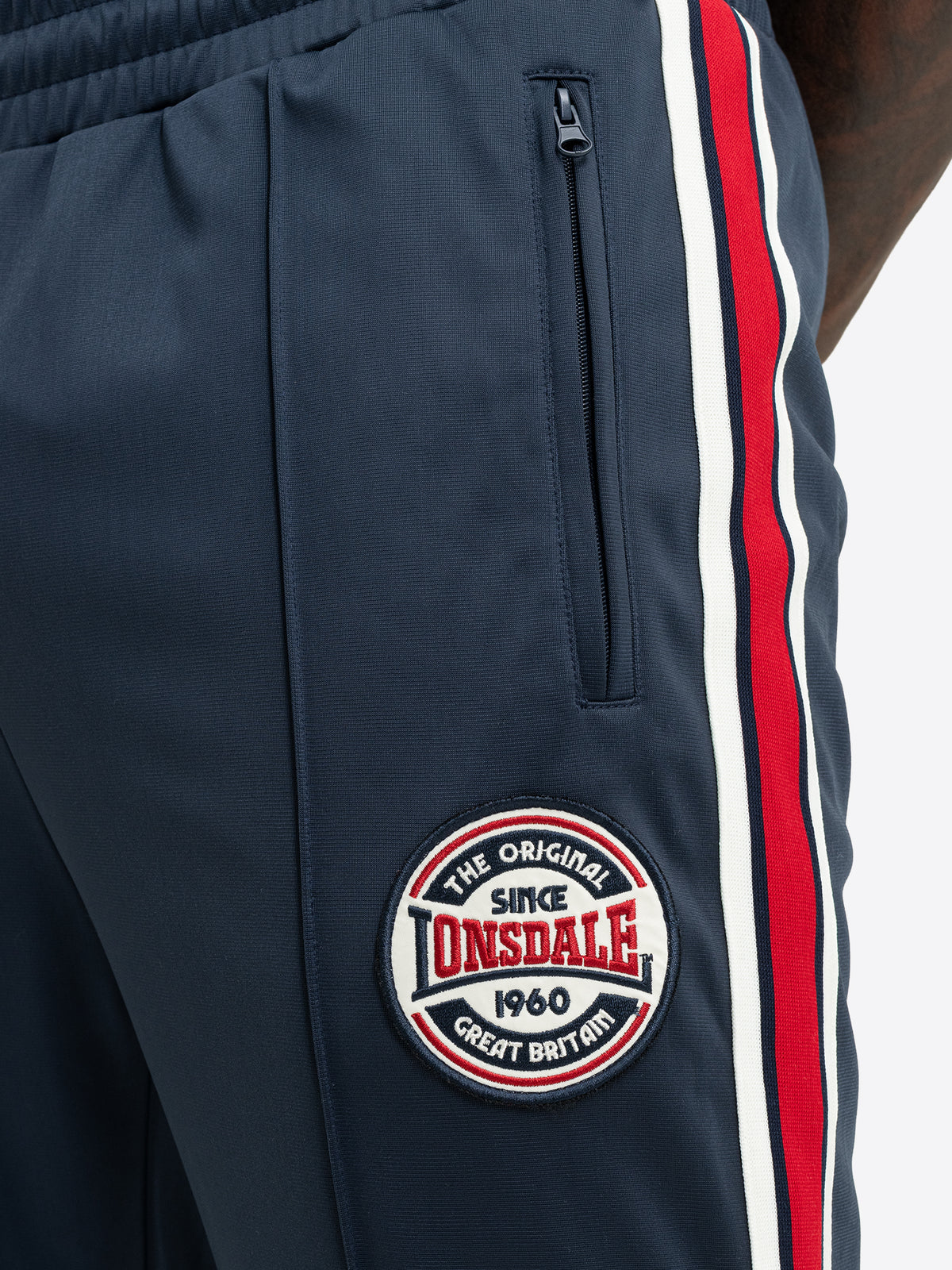 Detailansicht der dunkelblauen Lonsdale Jogginghose mit Logo-Patch und Schmuckbiese