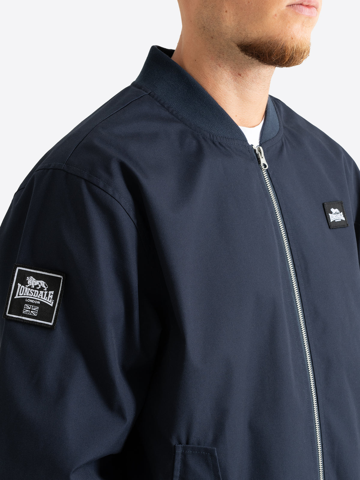 Detailansicht Lonsdale Herren Bomberjacke in Darknavy mit Logo Patches auf Aermel und Brust