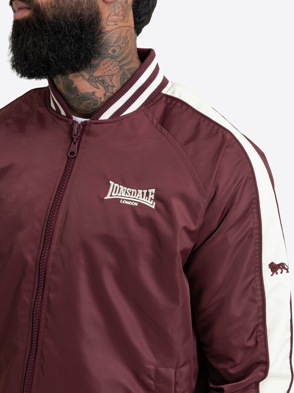 Nahaufnahme der Lonsdale Herren-Collegejacke in Oxblood mit Logo-Stickerei und gestreiftem Kragen