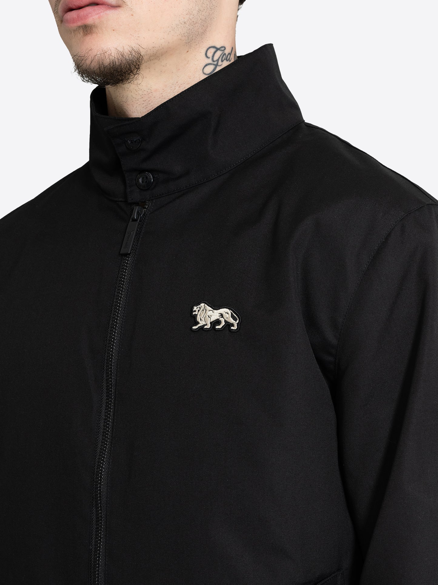 Detailansicht der schwarzen Lonsdale Jacke mit Stehkragen und weissem Löwen Badge auf der Brust