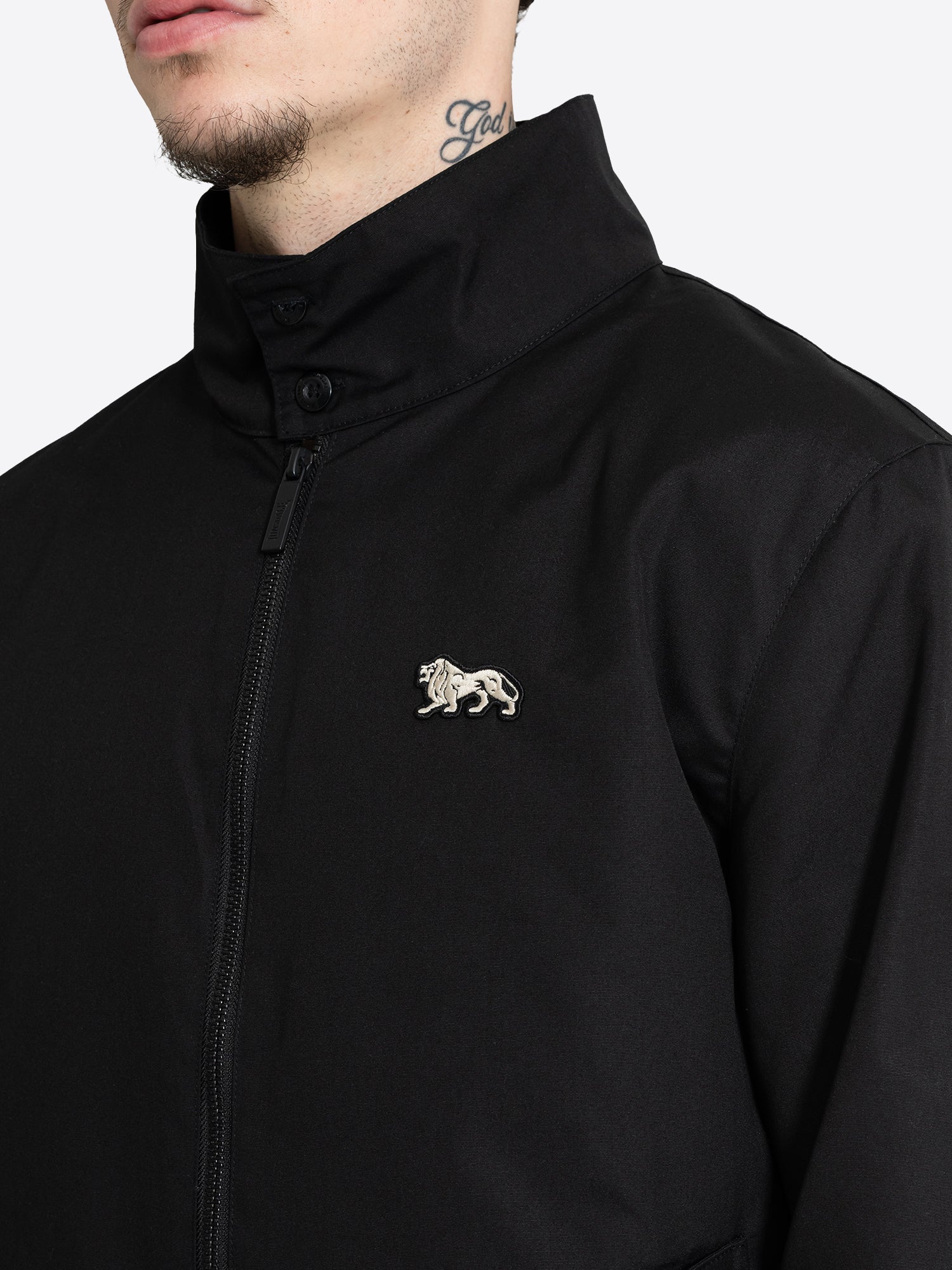 Detailansicht der schwarzen Lonsdale Jacke mit Stehkragen und weissem Löwen Badge auf der Brust