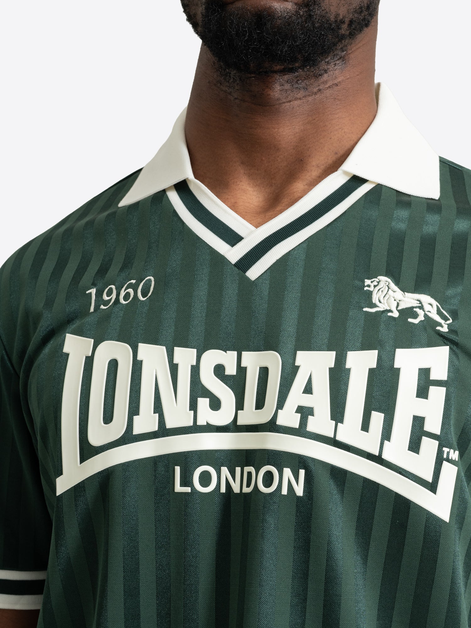 Grünes Lonsdale Trikot mit weissem Polokragen und grossem Logo-Aufdruck auf der Brust.