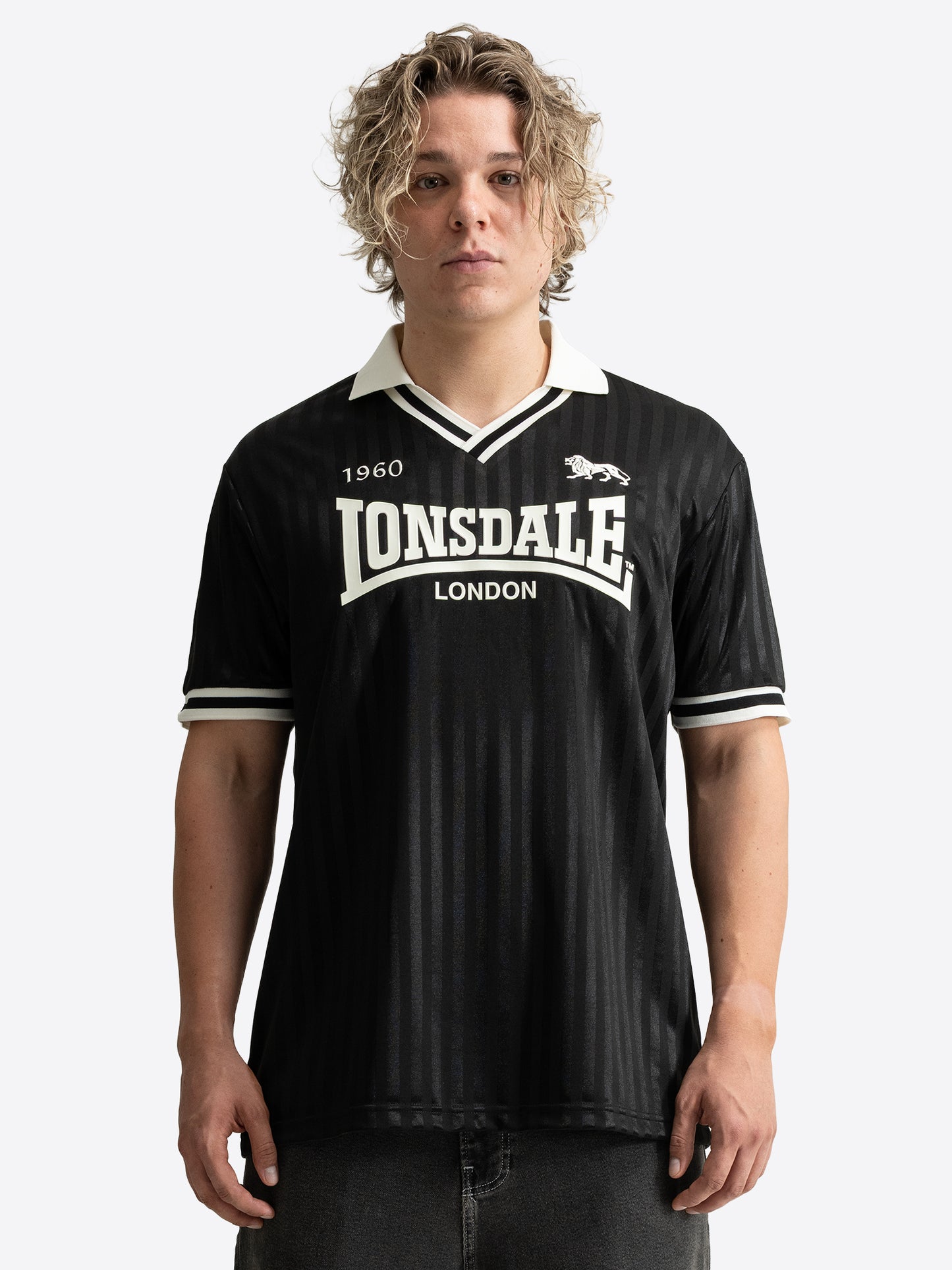 Lonsdale Unisex Trikot in Schwarz mit gestreiftem Jacquard-Muster, weissem V-Ausschnitt und Retro-Logo auf der Brust.