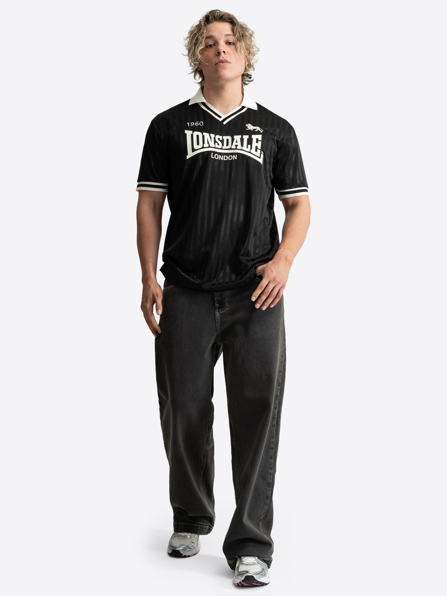 Lonsdale Unisex Trikot in Schwarz mit gestreiftem Jacquard-Muster, weissem V-Ausschnitt und Retro-Logo auf der Brust.