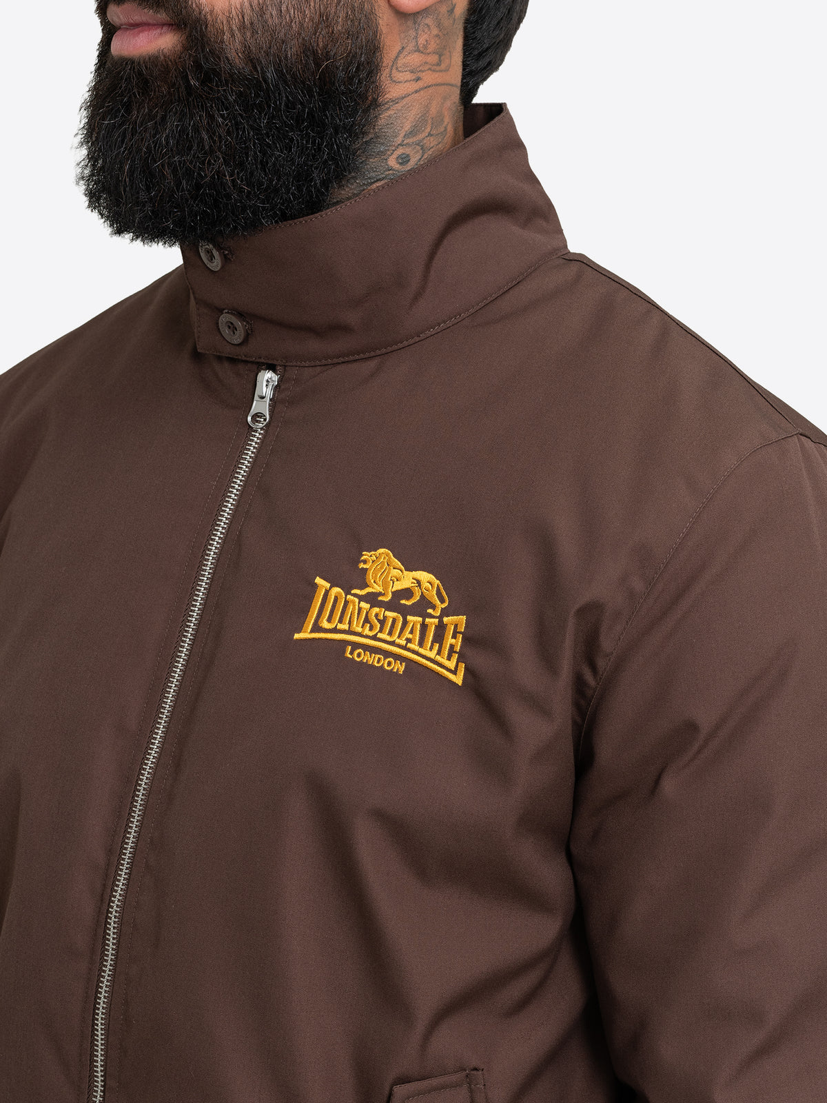 Detailansicht der braunen Lonsdale Herren Jacke mit gelb gesticktem Logo auf der Brust