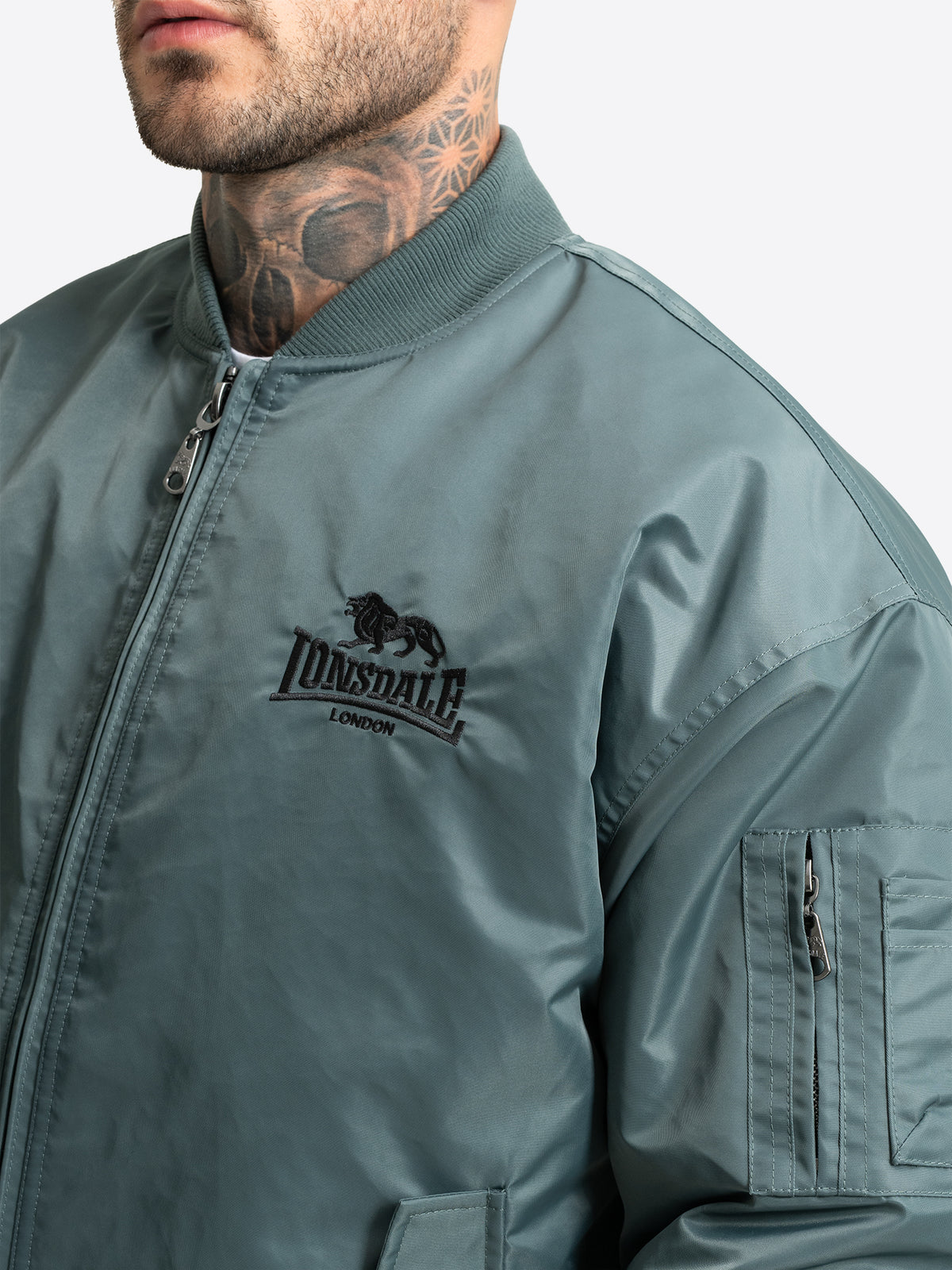 Lonsdale Bomberjacke Herren Oliv – Detail mit Logo-Stickerei und Ärmeltasche.