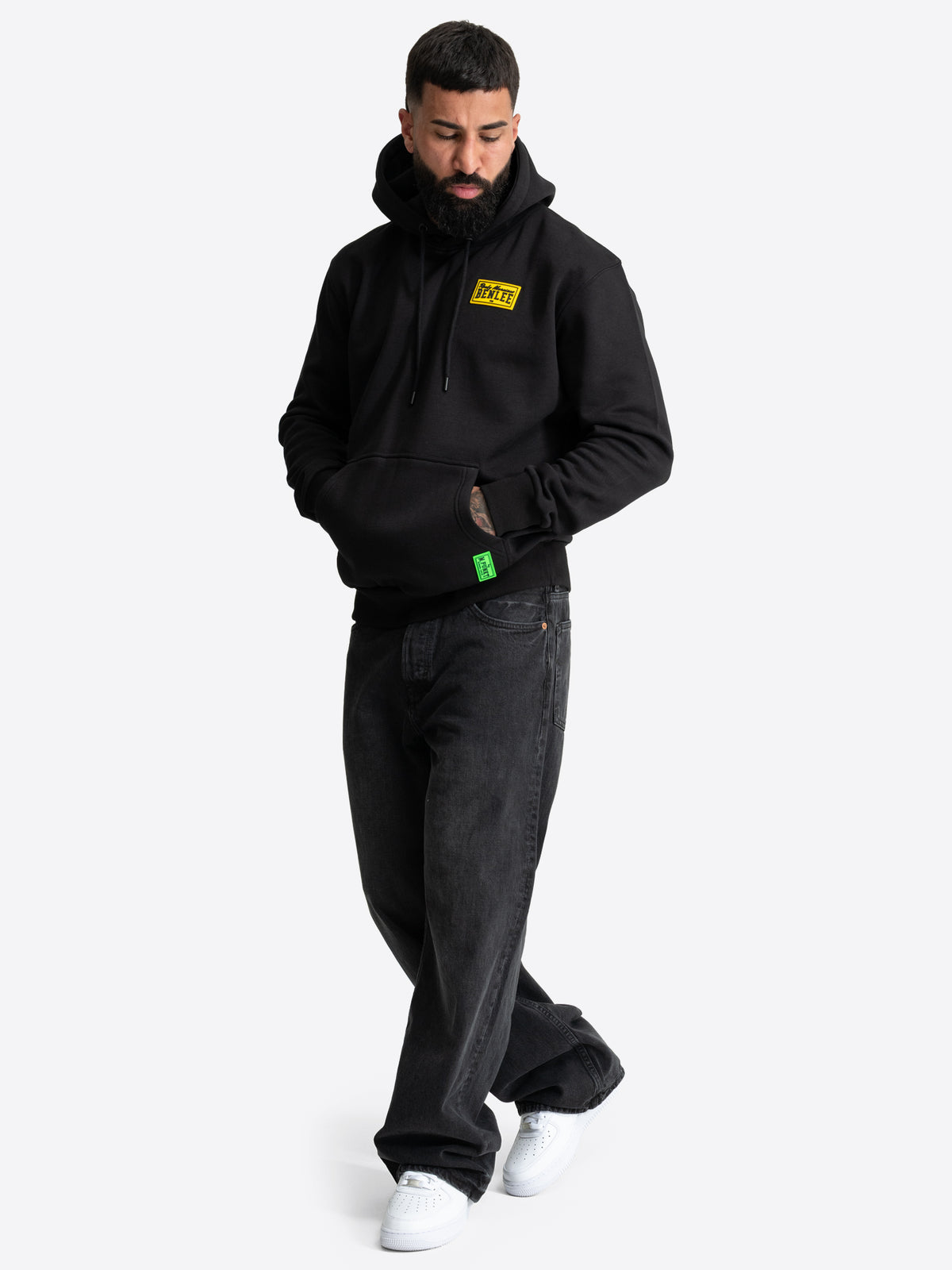 Schwarzer BENLEE Kapuzenpullover für Herren in normaler Passform mit Kängurutasche und gelbem Logo-Patch auf der Brust.

