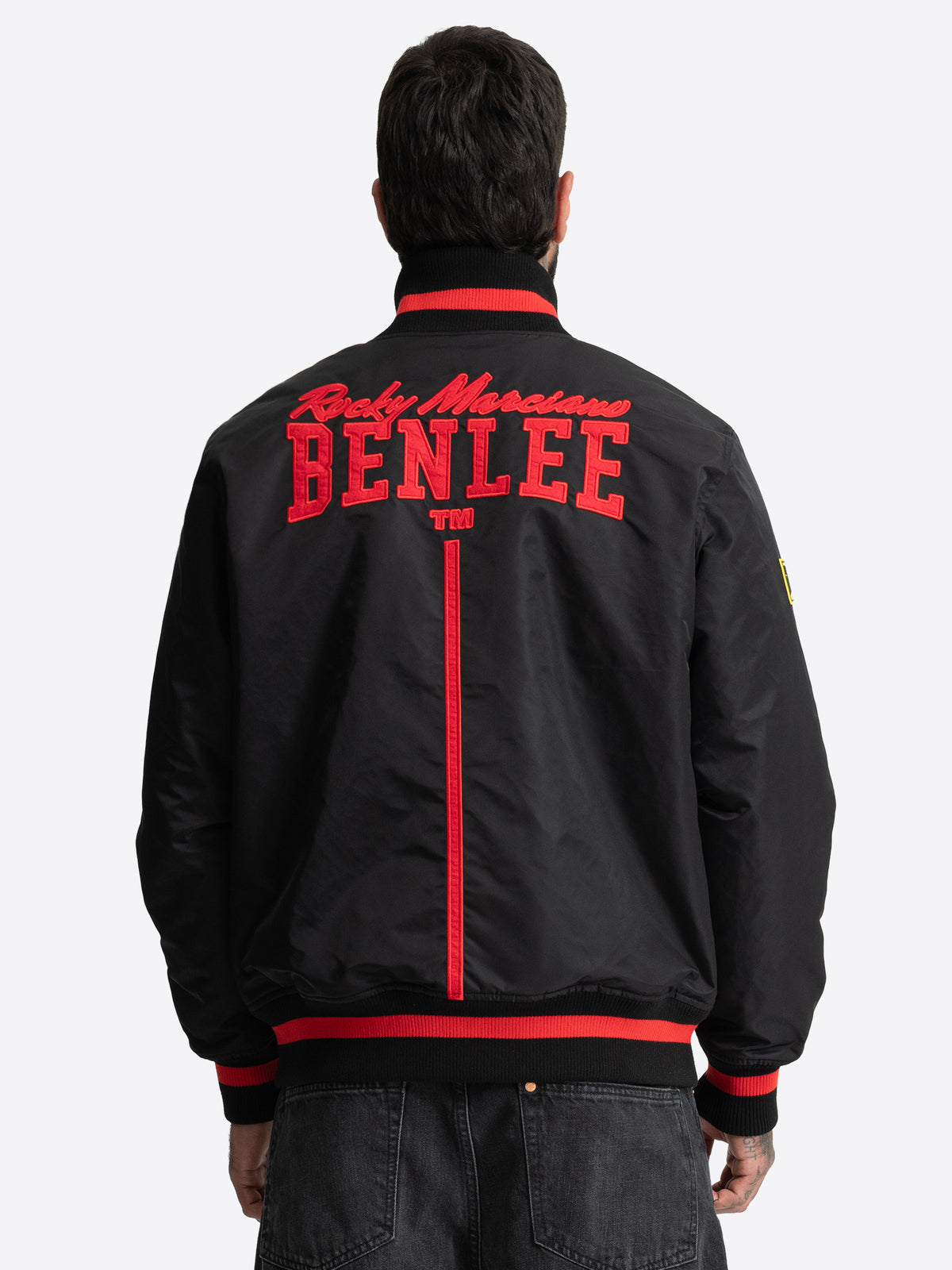 Rückansicht der schwarzen BENLEE Herren-Collegejacke mit rotem Stickerei-Logo.