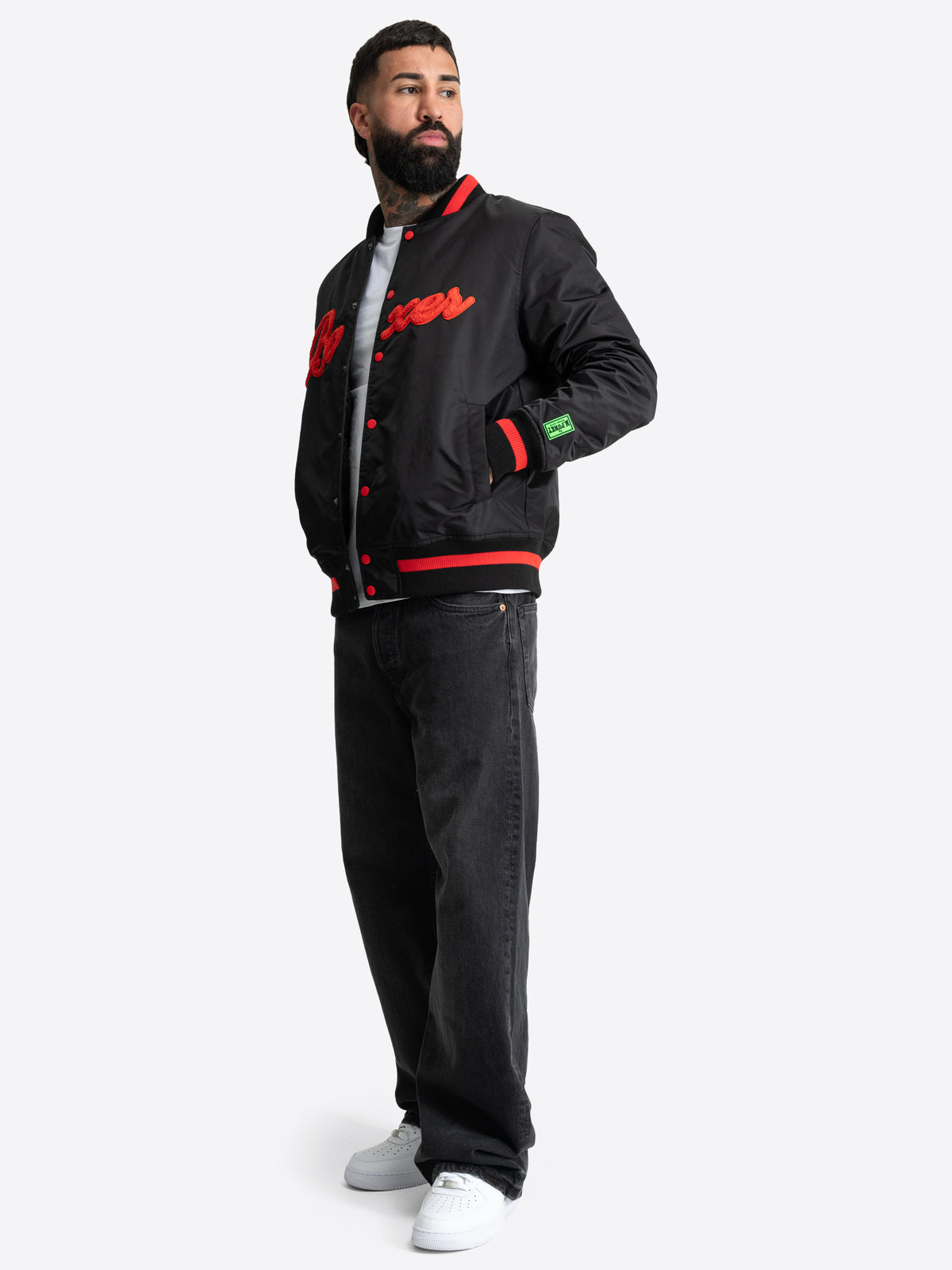 Schwarze BENLEE Herren-Collegejacke in normaler Passform mit rotem Boxer-Schriftzug auf der Brust.
