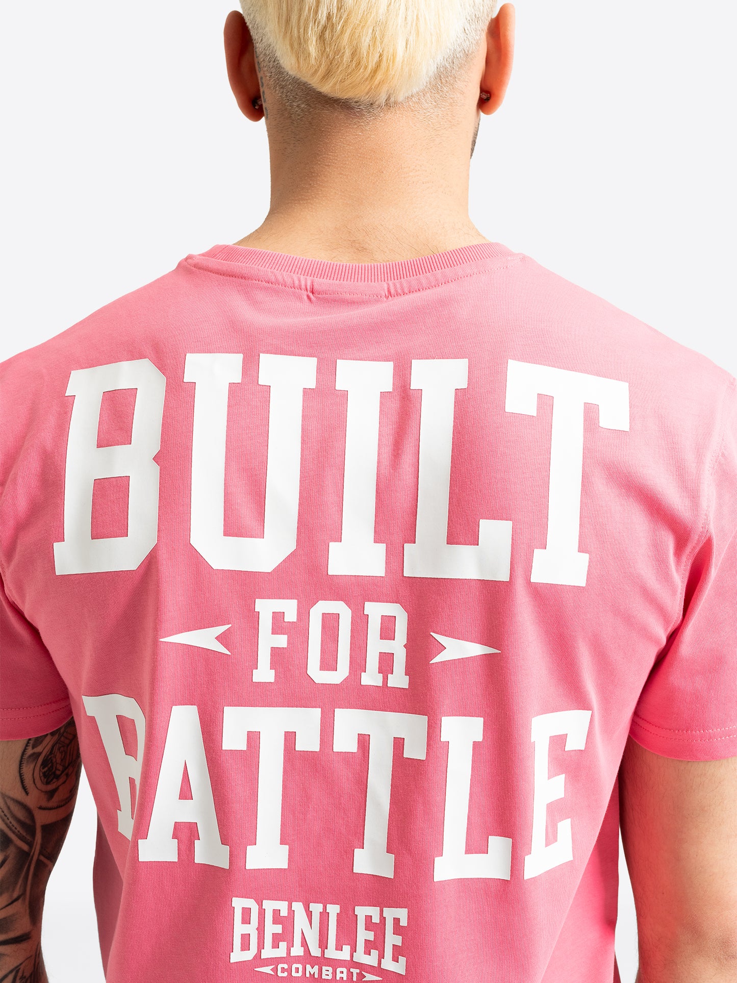 Detailansicht des weissen BUILT FOR BATTLE Rückenprints auf pinkem T-Shirt.