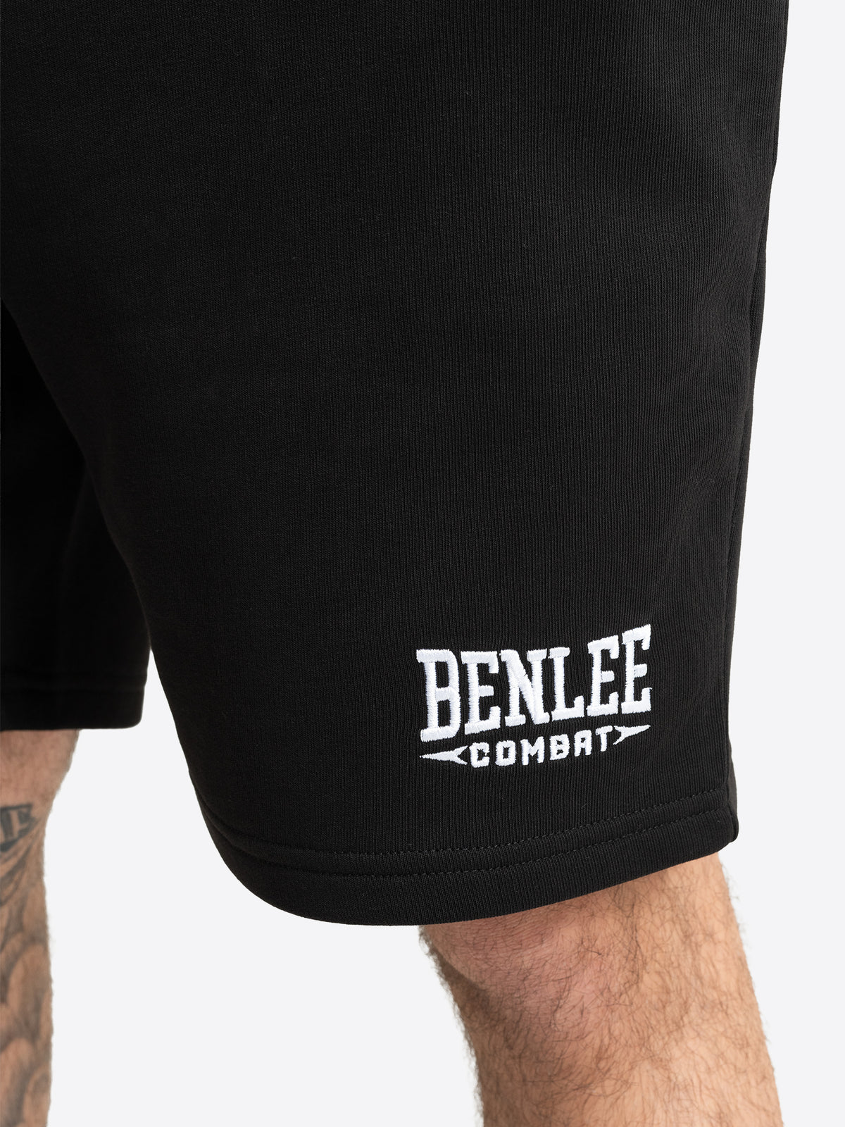 Detailansicht der schwarzen BENLEE Herren-Shorts mit aufgesticktem weissen Logo über dem Hosensaum.
