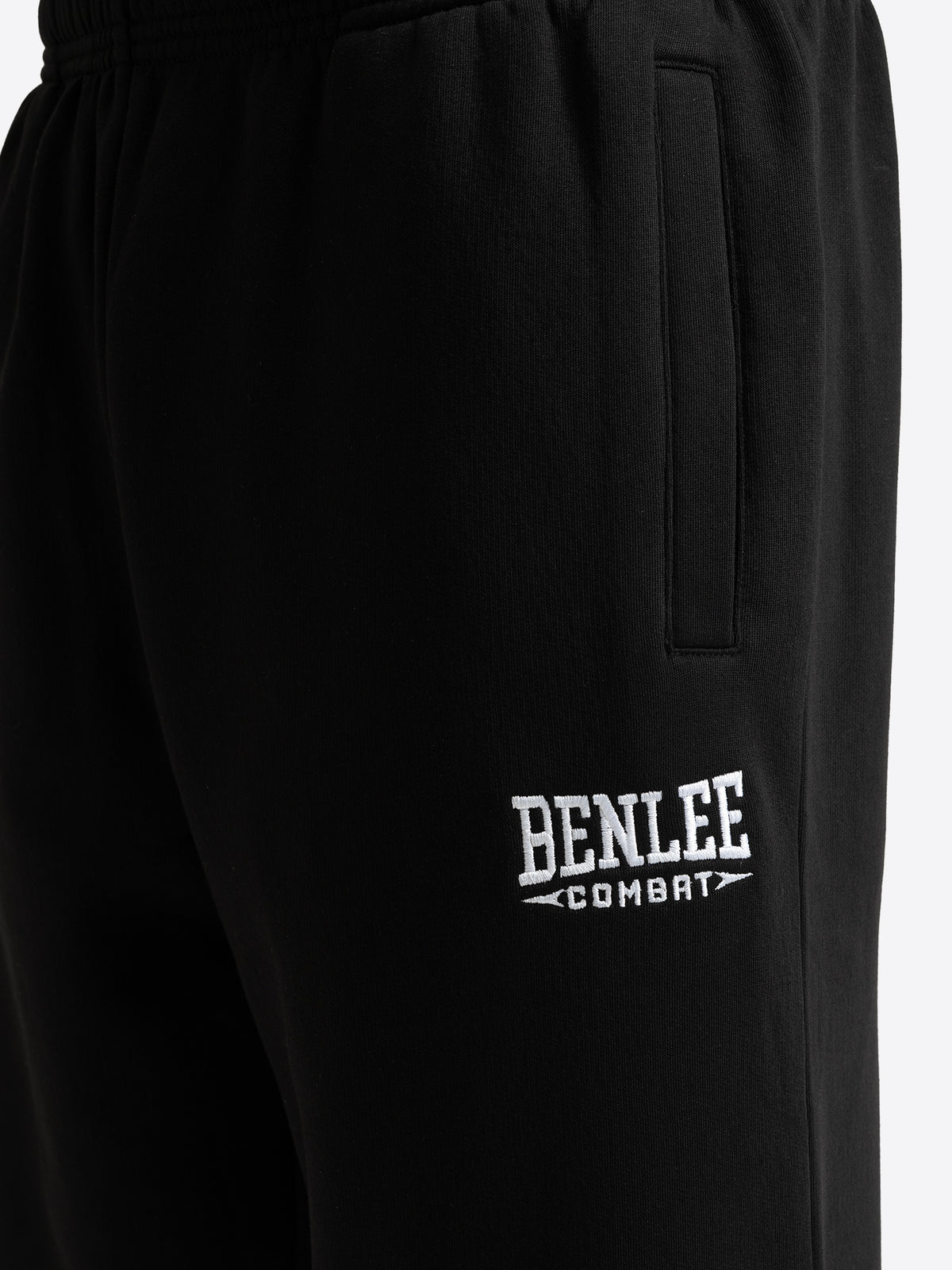 Detailansicht der schwarzen BENLEE Herren-Jogginghose mit aufgesticktem weissen Logo und Eingrifftasche.

