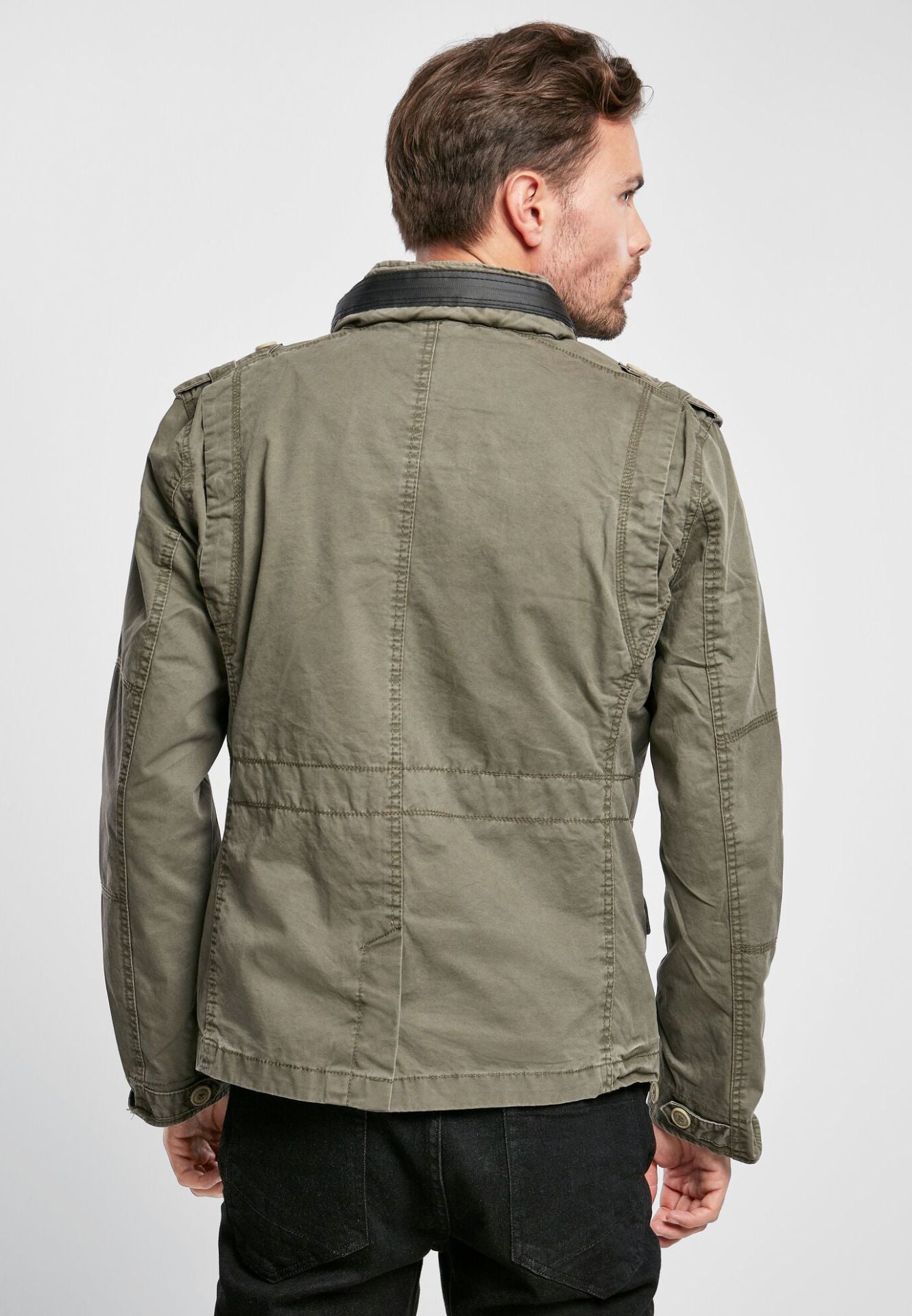 Brandit modifizierte Feldjacke in Oliv mit Logo-Badge, versteckter Kapuze im Kragen, Stehkragen mit Kunstlederapplikation und Used-Effekten.