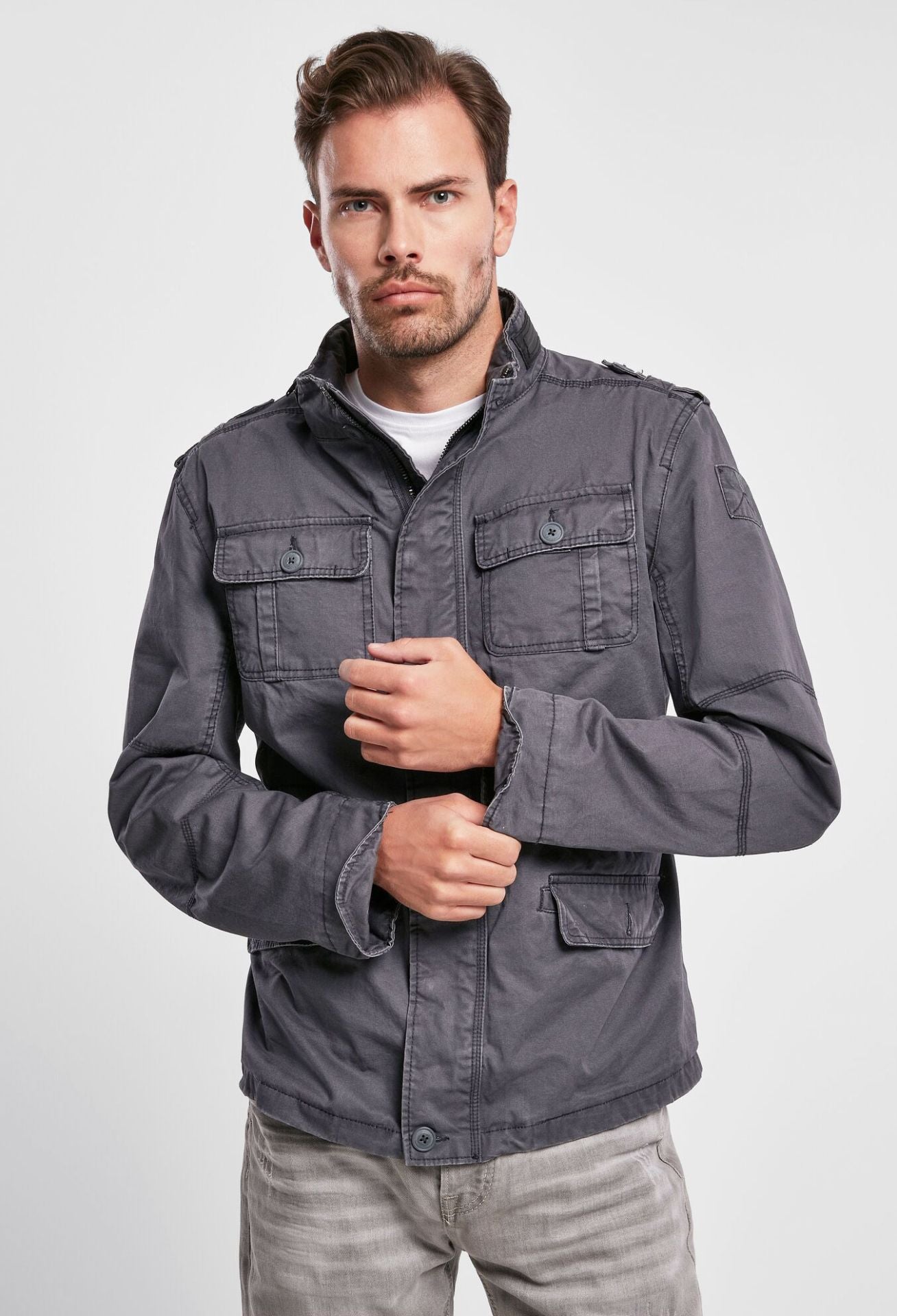 Brandit modifizierte Feldjacke in Indigo mit Logo-Badge, versteckter Kapuze im Kragen, Stehkragen mit Kunstlederapplikation und Used-Effekten.