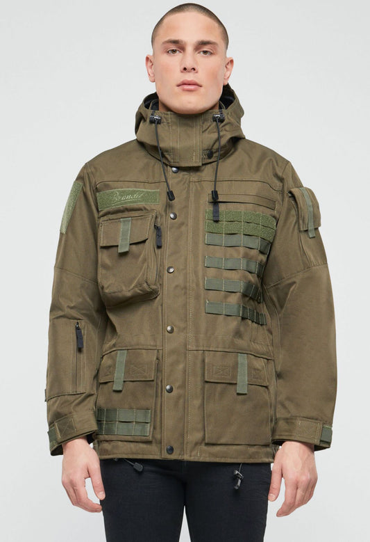 Olivfarbene Brandit taktische Performance-Jacke aus wasserabweisendem Material mit abnehmbarer Kapuze, verstellbarer Taille, Molle-Bändern und vielen Taschen.